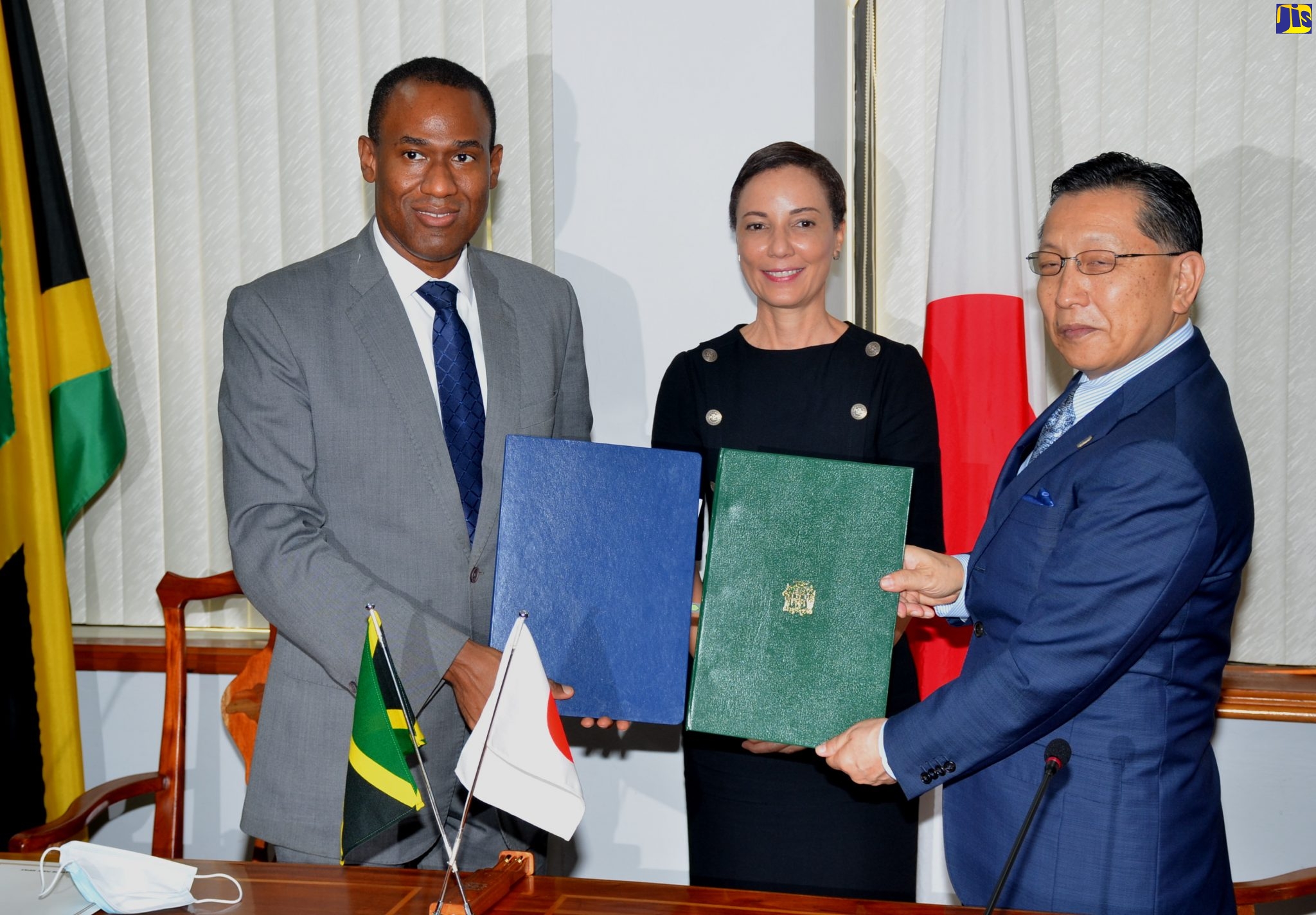 Minister of Finance and the Public Service, Dr. the Hon. Nigel Clarke (left); and Japan’s Ambassador to Jamaica, His Excellency Hiromasa Yamazaki (right), display signed agreements formalising the Government of Japan’s provision of approximately $262 million (¥200 million) in grant aid, to boost the Administration’s national coronavirus response. Sharing the moment is Minister of Foreign Affairs and Foreign Trade, Senator the Hon. Kamina Johnson Smith. The signing took place at the Finance Ministry in Kingston, on Tuesday (June 16).