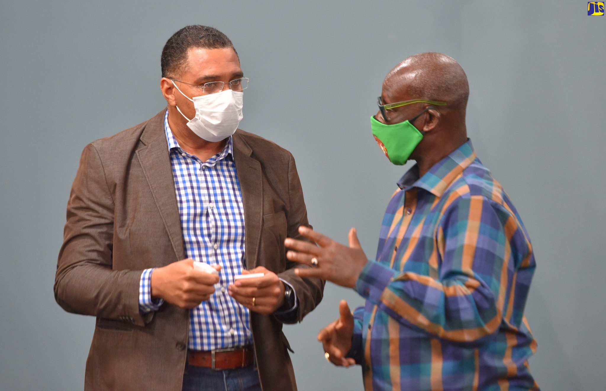 Prime MInister, the Most Hon. Andrew Holness (left), conversing with Minister of Local Government and Community Development, Hon. Desmond McKenzie, during a digital press briefing at the Office of the Prime Minister in St. Andrew on June 12.