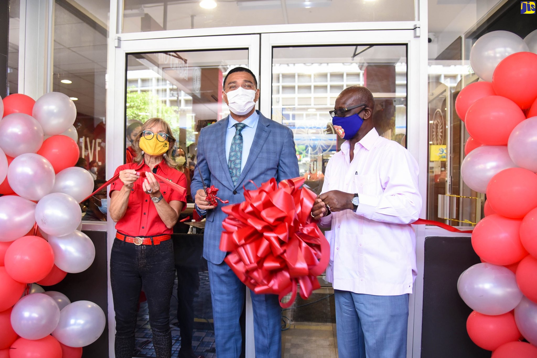 Prime Minister, the Most Hon. Andrew Holness (centre), cuts the ribbon symbolising the official opening of Island Grill’s new restaurant on King Street in downtown Kingston, on July 2. Also participating in the exercise are (from left) Founder and Chief Executive Officer of Island Grill, Thalia Lyn; and Minister of Local Government and Community Development, and Member of Parliament for the area, Hon. Desmond McKenzie.