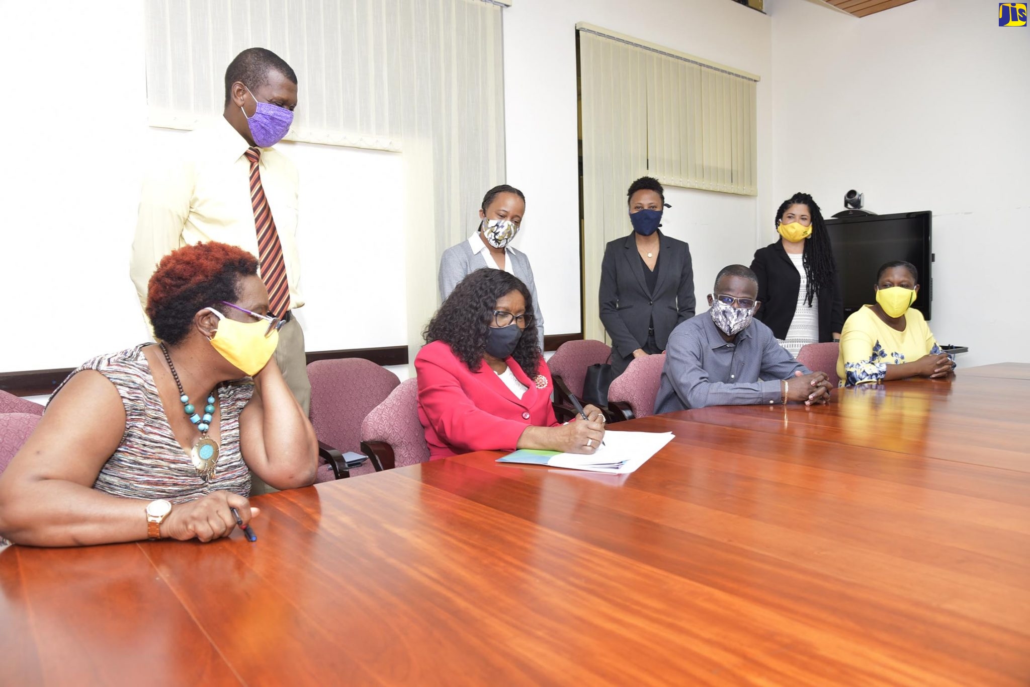 Permanent Secretary in the Ministry of Economic Growth and Job Creation, Audrey Sewell (second left, seated), signs a Green Climate Fund  (GCF)grant agreement recently at Jamaica House.  The GCF is providing two grants, totalling $120.3 million (US$855,546), to undertake projects under the Economic Growth and Culture, Gender, Entertainment and Sport Ministries.  Looking on (from left, seated) are Principal Director, Climate Change Division (CCD, Una-May Gordon; Permanent Secretary, Ministry of Culture, Gender, Entertainment and Sport, Denzil Thorpe; and Director, Policy and Research, Bureau of Gender Affairs (BGA), Sharon Coburn Robinson. (From left, standing) are CCD representatives -- Senior Technical Officer (Mitigation), Omar Alcock; Climate Finance Advisor, Katherine Blackman; Senior Technical Officer (Adaptation), Le-Anne Roper; and Technical Officer, Kathryn Duncan.