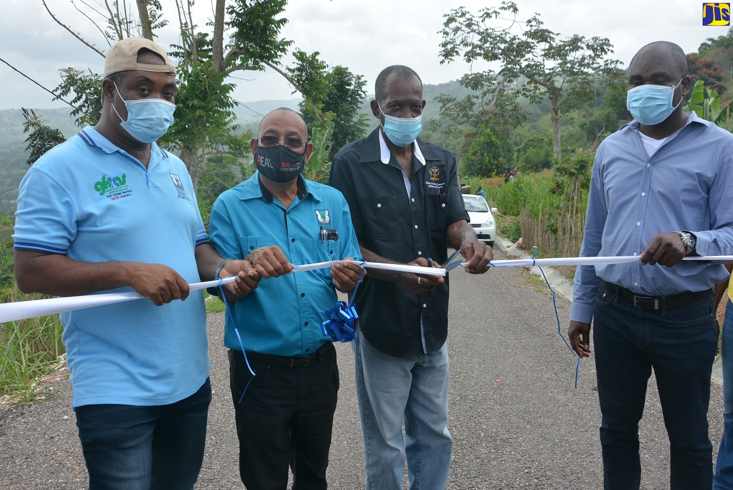 Former Minister without Portfolio in the Ministry of Industry, Commerce, Agriculture and Fisheries, Hon. J.C. Hutchinson (second right), cuts the ribbon to mark the official opening of a farm road in Bingham Hill, St. Ann, on Thursday, July 16. Looking on (from left) are Chief Executive Officer (CEO) of the Rural Agricultural Development Authority (RADA), Peter Thompson (left); RADA’s Director of Engineering Services, Lennoy Prendergast; and Member of Parliament for South West St. Ann, and State Minister for Labour and Social Security, Hon. Zavia Mayne.