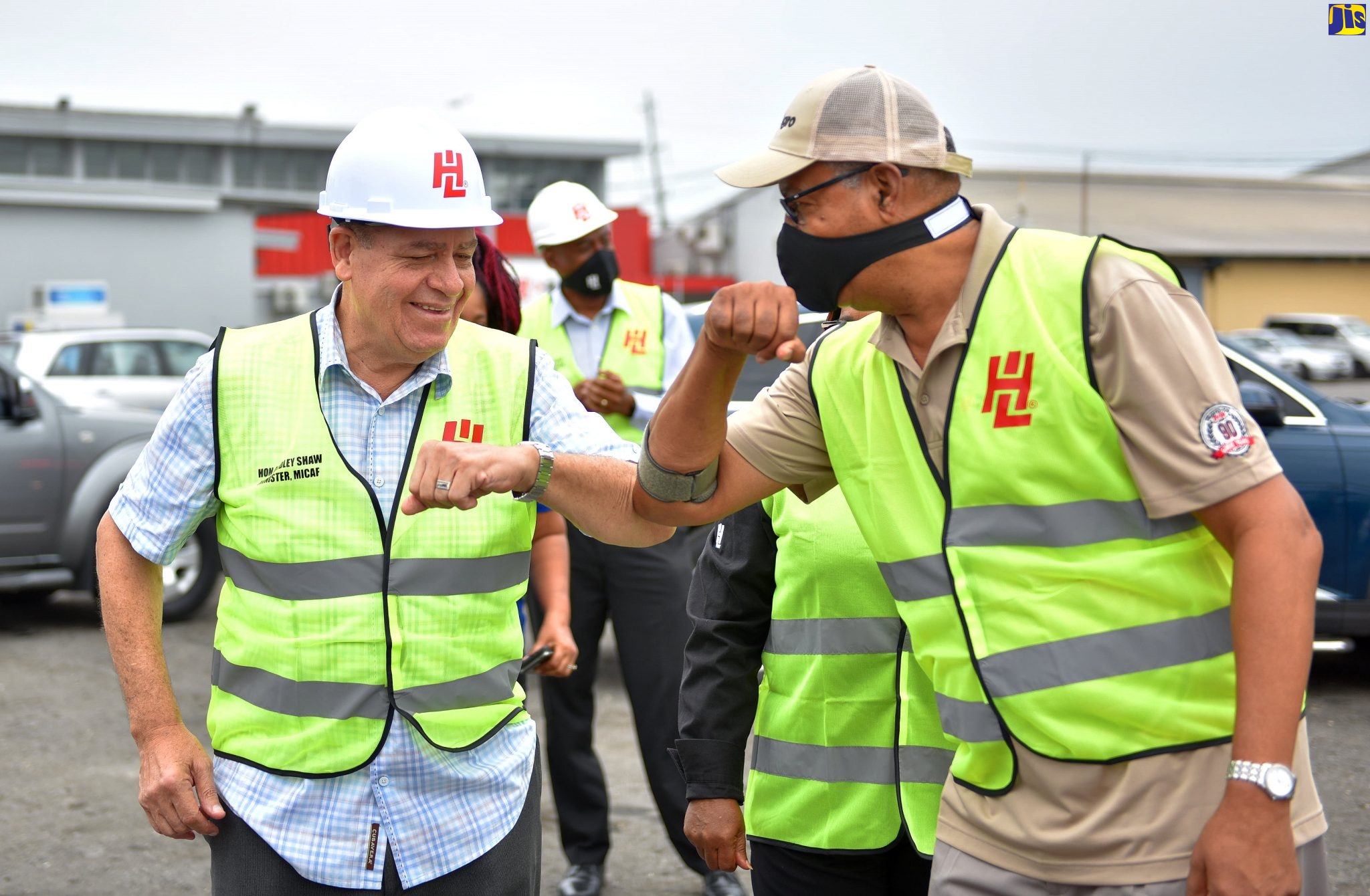 Minister of Industry, Commerce, Agriculture and Fisheries, tHon. Audley Shaw (left) and Board Chairman, Hardware & Lumber (H&L), Erwin Burton, greet each other by knocking elbows. Occasion was a ceremony for the handover of agricultural inputs by H&L Agro to small farmers, held May 21 at the the H&L outlet located along Spanish Town Road, Kingston.
