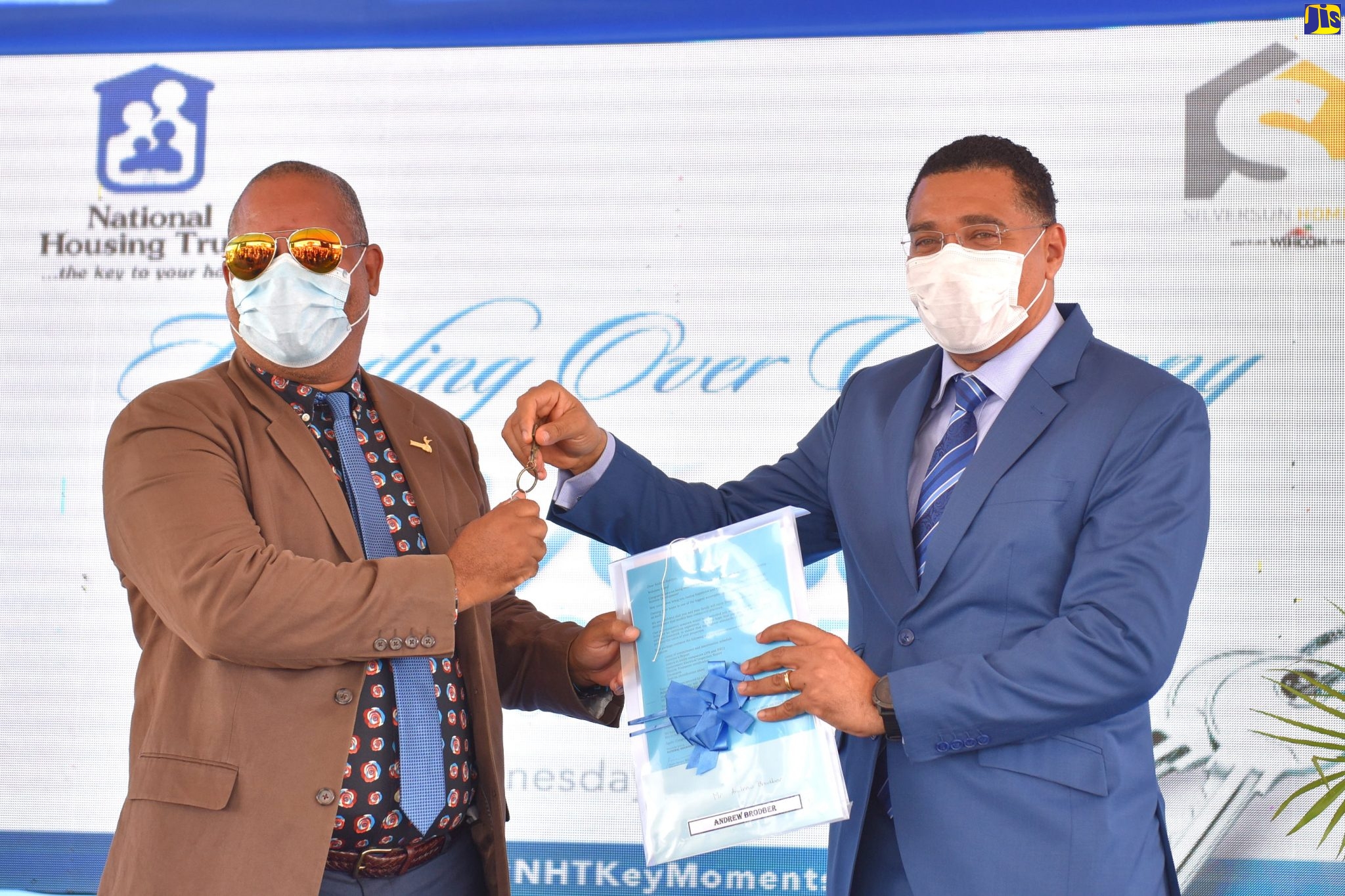 Prime Minister, the Most Hon. Andrew Holness (right), presents new homeowner, Andrew Brodber, with his keys at the official opening of the SilverSun Estates housing development in St. Catherine, today (July 1). Mr. Holness handed over keys to 50 new homeowners.