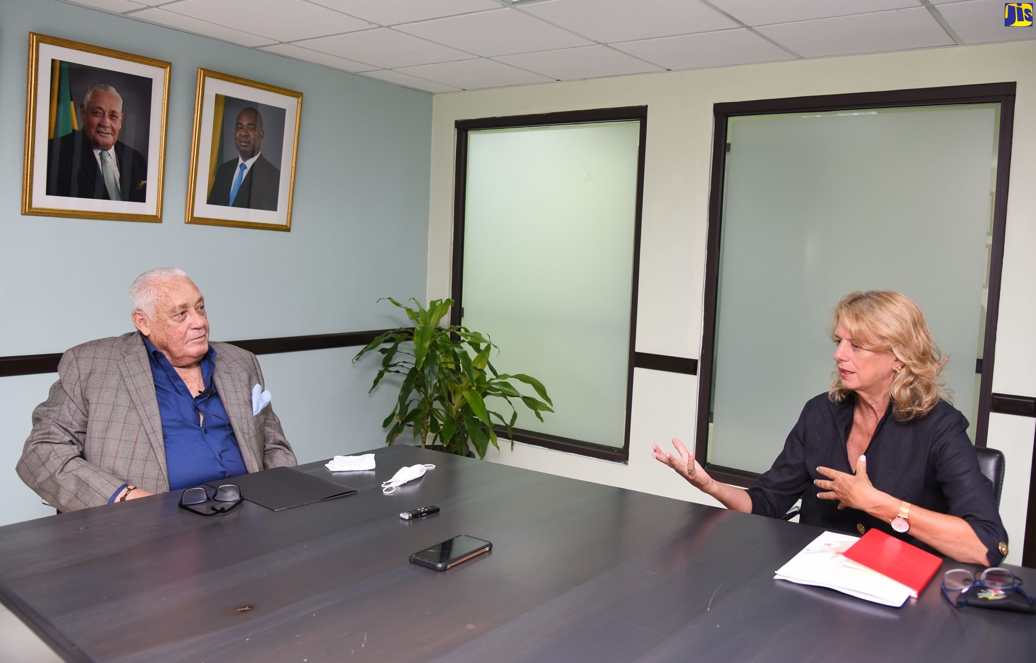 Minister of Labour and Social Security, Hon. Lester Michael Henry (left), listens to Canadian High Commissioner, Her Excellency Laurie Peters, when she visited the Ministry in Kingston, on Wednesday (July 8).