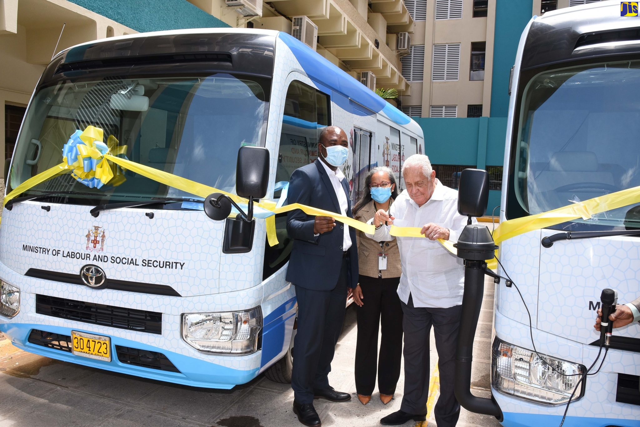 Minister of Labour and Social Security, Hon. Mike Henry (right), cuts the ribbon to commission into service two mobile units at the Ministry’s downtown Kingtson offices on Thursday (July 9). Sharing the moment are Permanent Secretary in the Ministry, Collette Roberts-Risden (centre); and State Minister, Hon. Zavia Mayne.