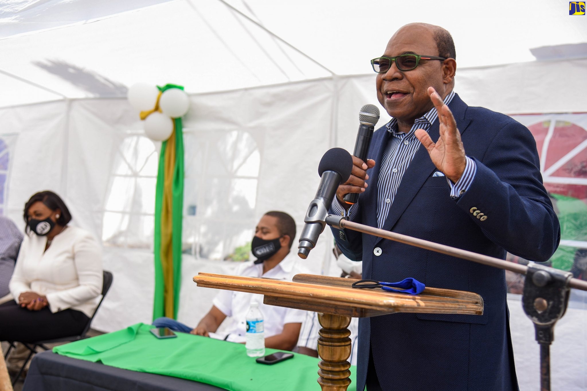 Minister of Tourism, Hon. Edmund Bartlett, addresses the recent official opening of the $253-million rehabilitated Guava Ridge to Content Gap road in East Rural St. Andrew. Listening (from left) are Member of Parliament for East Rural St. Andrew and wife of the Prime Minister, the Most Hon. Juliet Holness; and Minister of State in the Ministry of Industry, Commerce, Agriculture and Fisheries, Hon. Floyd Green.