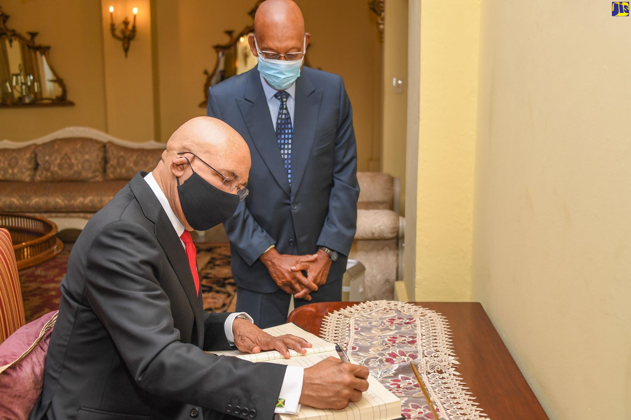 Governor-General, His Excellency, the Most Hon. Sir Patrick Allen, signs the condolence book for the late former Prime Minister of Barbados, Owen Arthur, at King’s House on Monday (August 17). Observing is Honorary Consul of Barbados, Winston Bayley