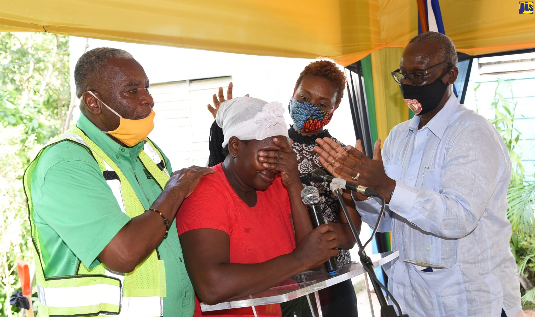Michelle Cookhorn (second left) breaks down in tears at the recent ceremony to break ground for her new home at Grant Hill in Lawrence Tavern, St. Andrew, which is being built by the Ministry of Local Government and Community Development. Portfolio Minister, Hon. Desmond McKenzie (right); Member of Parliament for West Rural St. Andrew, Juliet Cuthbert-Flynn (second right) and Councillor, Lawrence Tavern Division, John Myers, share in the emotional moment.