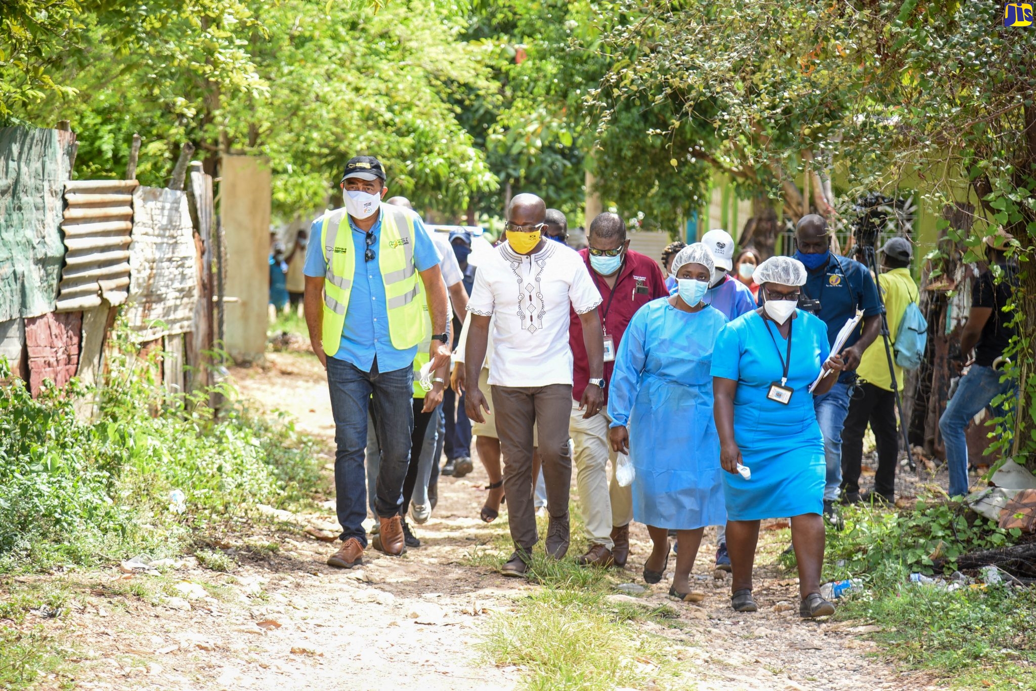 Minister of Health and Wellness, Dr. Hon. Christopher Tufton (foreground, left), along with Member of Parliament for South East Clarendon, Pearnel Charles Jnr. (foreground, second left) accompanied by health officials, tour sections of the recently quarantined Sandy Bay community in Clarendon on Friday (April 7). The Government imposed a 14-day quarantine in the community following a recent increase in coronavirus (COVID-19) cases. A public health team is in the area conducting contact tracing, sampling of persons and public education. The quarantine became effective at 6:00 am on Thursday (August 6) and will run until 6:00 a.m. on Thursday (August 20). The Church Corner community in St. Thomas was also placed under a 14-day quarantine on August 6.