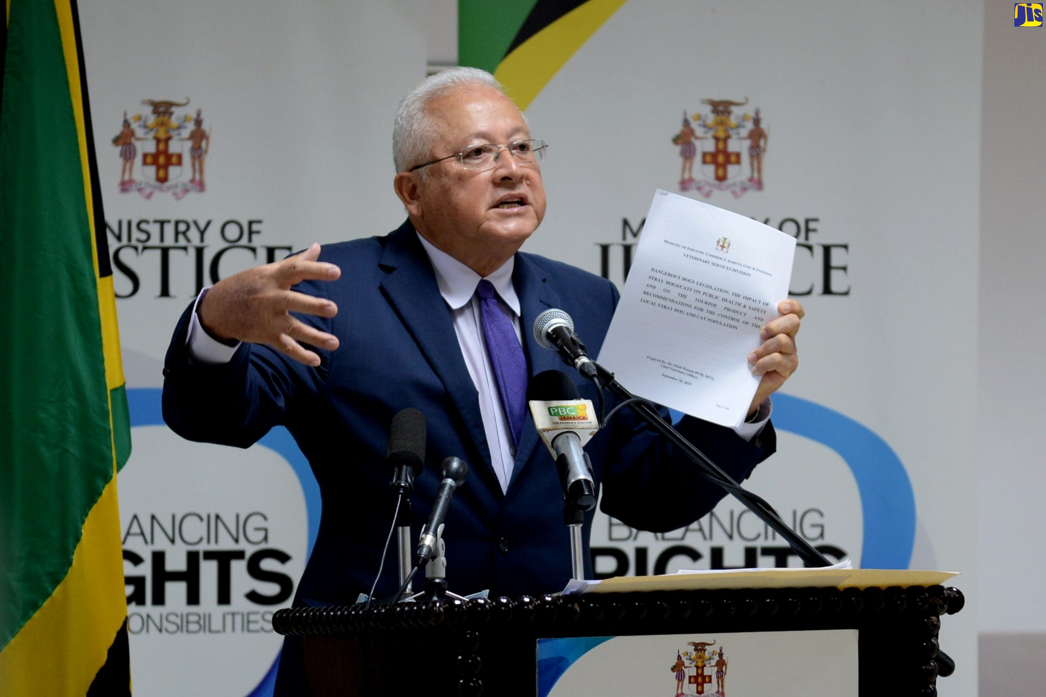 Minister of Justice, Hon. Delroy Chuck, refers to a document while addressing the quarterly press briefing of the Ministry ​in St. Andrew on Friday (July 31).  
