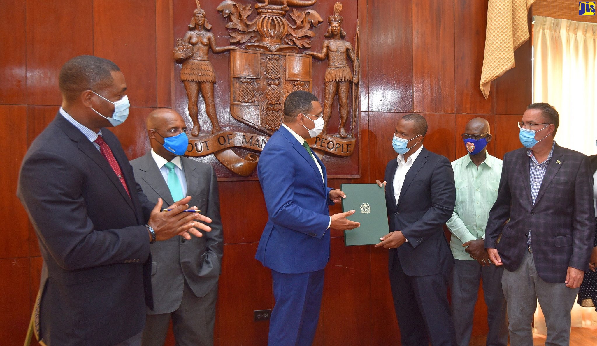Prime Minister, the Most Hon. Andrew Holness (third left), hands over a signed copy of  a  contract  to Director, M & M Jamaica Limited, Richard Mullings (third right), at Jamaica  House on Wednesday (August 12). The contract is for the improvement of water supply from Six Miles to Blake Road in Kingston. Sharing the moment  (from left) are President, National Water Commission (NWC), Mark Barnett; Chairman, NWC, Senator Aubyn Hill; Minister of Local Government and Community Development,  Hon. Desmond McKenzie, and  Minister without Portfolio in the Ministry of Economic Growth and Job Creation with responsibility for Water and Housing,  Hon. Daryl Vaz.