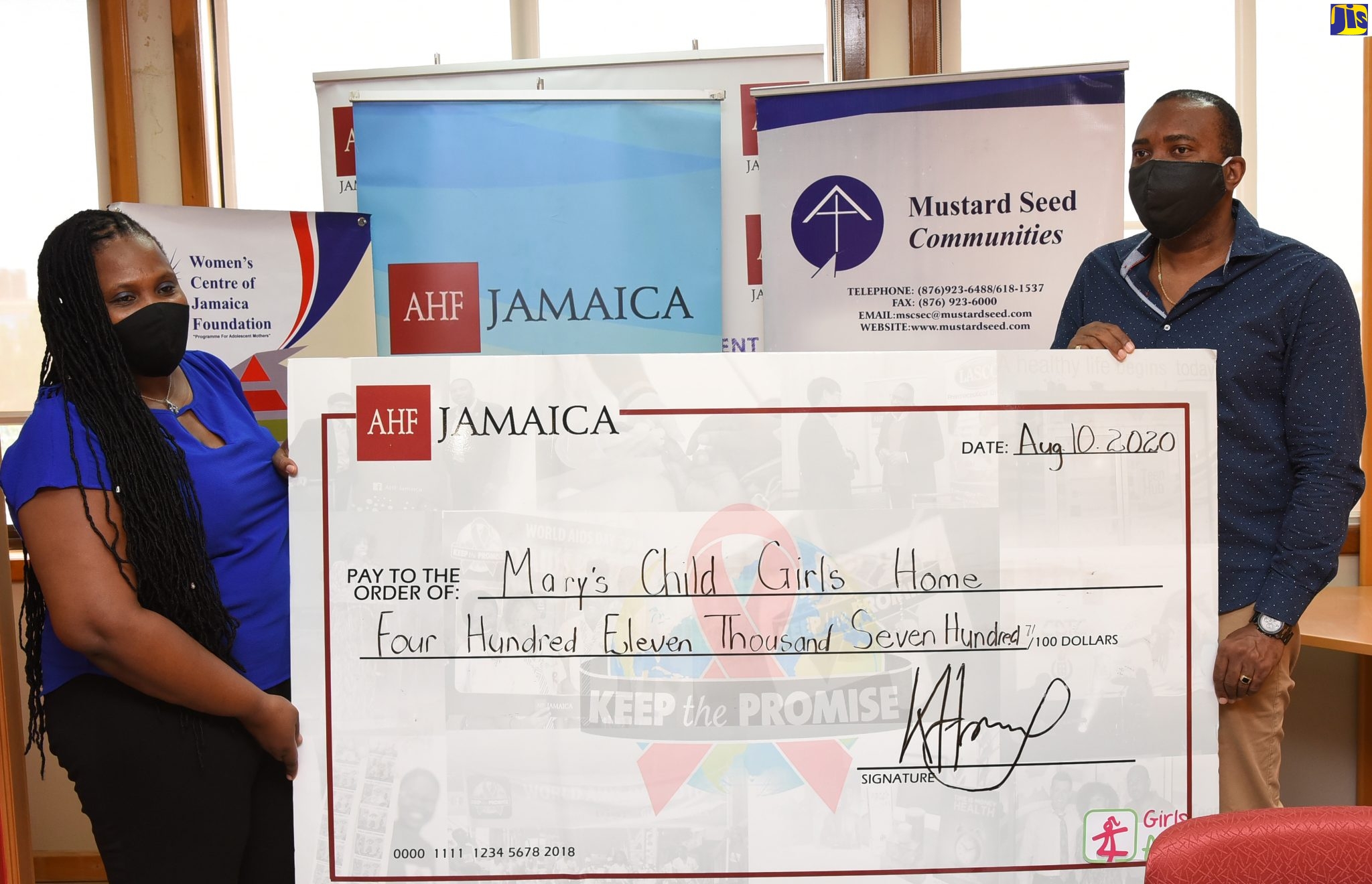 Regional Director, AIDS Healthcare Foundation (AHF), Dr. Kevin Harvey (right), presents a cheque valued at $411,700 to Administrator, Mary’s Child, Nadia Williams, during a ceremony at the AHF offices in St. Andrew on August 10.