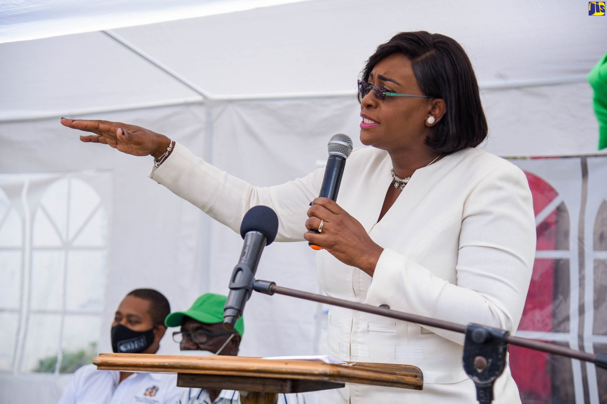 Member of Parliament for East Rural St. Andrew, and Wife of the Prime Minister, the Most Hon. Juliet Holness, addresses the recent ceremony to officially open the Guava Ridge to Content Gap roadway in the constituency, following its rehabilitation at a cost of $253 million. With Mrs. Holness (from left) are Minister of State in the Ministry of Industry, Commerce, Agriculture and Fisheries, Hon. Floyd Green; and Councillor for the Mavis Bank Division, Alvin Francis.