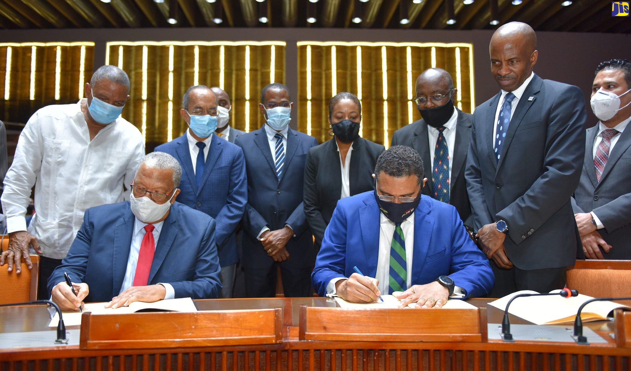 Prime Minister the Most Hon. Andrew Holness (seated  right), along with Leader of the Opposition, Dr. Peter Phillips (seated left) sign a Memorandum of Understanding (MOU) on the National Consensus on Crime at the crime consensus summit held at the Jamaica Conference Centre, downtown Kingston on August 3. Others observing (from left standing) are Member of Parliament for Northern Clarendon, Horace Dalley; Minister of National Security, Hon. Dr. Horace Chang; Member of Parliament for South East St. Andrew, Julian Robinson; Minister of Finance and the Public Service, Dr. the Hon. Nigel Clarke; Attorney General, Marlene Malahoo Forte; Opposition Spokesperson on National Security, Fitz Jackson;  Chair, Working Group, National Consensus of Crime, Lloyd Distant; and Minister without Portfolio in the Ministry of National Security, Hon. Matthew Samuda.