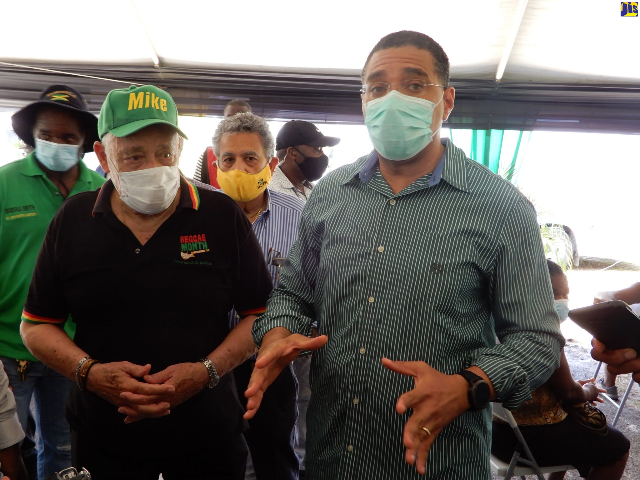 Prime Minister, the Most Hon. Andrew Holness (second left), responds to questions from JIS News, following a tour of the Ministry of Labour and Social Security’s two new mobile units, in St. Ann’s Bay, St. Ann, on August 5. With the Prime Minister is Portfolio Minister, Hon. Mike Henry (left).