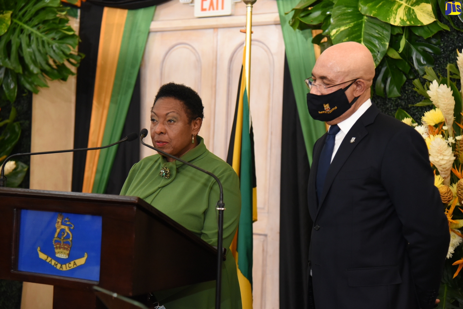 Governor-General, His Excellency the Most Hon. Sir Patrick Allen (right), observes while Minister of Culture, Gender, Entertainment and Sport, Hon. Olivia Grange, takes the Oath of Office during Sunday