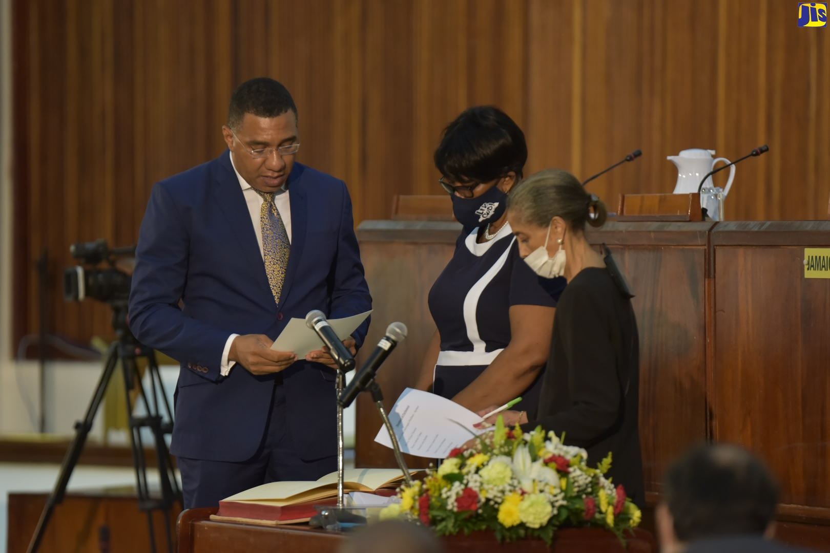 Prime Minister, the Most Hon. Andrew Holness (left), takes the Oath of Allegiance as he is sworn in during a sitting of the House of Representatives at the Jamaica Conference Centre in downtown Kingston on Tuesday (Sept. 15). At right is Clerk to the Houses of Parliament, Mrs. Heather Cooke, while at centre is Deputy Clerk, Ms. Valrie Curtis.