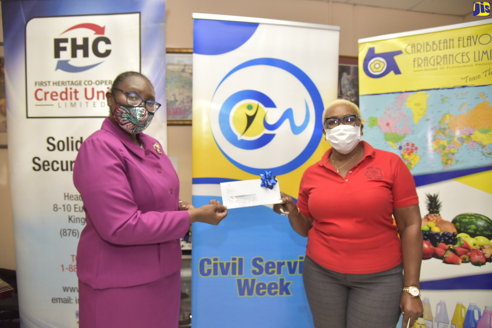 Acting Director, Research, Print and Production Division, Jamaica Information Service (JIS), Celia Lindsay (left), makes a presentation to Principal, National Baptist Basic School, Pauline Davis, on Tuesday (September 29), at the offices of Caribbean Flavours and Fragrances Limited, on Spanish Town Road in Kingston.
