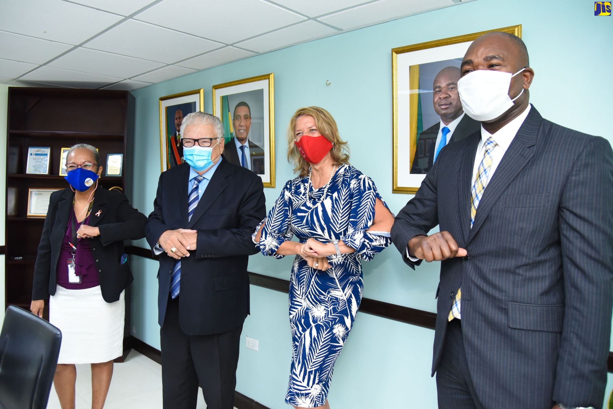 Labour and Social Security Minister, Hon. Karl Samuda (second left), exchanges elbow bump greetings with Canadian High Commissioner to Jamaica, Her Excellency Laurie Peters (second right), during a courtesy call by the High Commissioner at the Ministry’s downtown Kingston offices on Wednesday (October 14). Sharing in the moment are Permanent Secretary in the Ministry, Colette Roberts-Risden; and State Minister, Hon. Zavia Mayne.