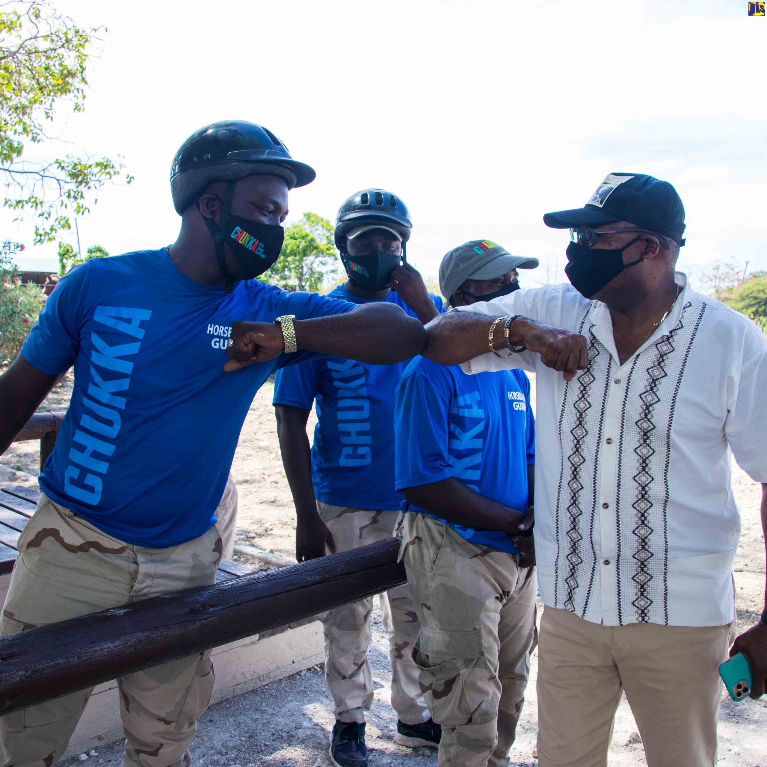 Minister of Tourism, Hon Edmund Bartlett (right), receives a COVID-style greeting from employees of Chukka Caribbean Adventures, during his tour of several Ocho Rios based attractions recently.