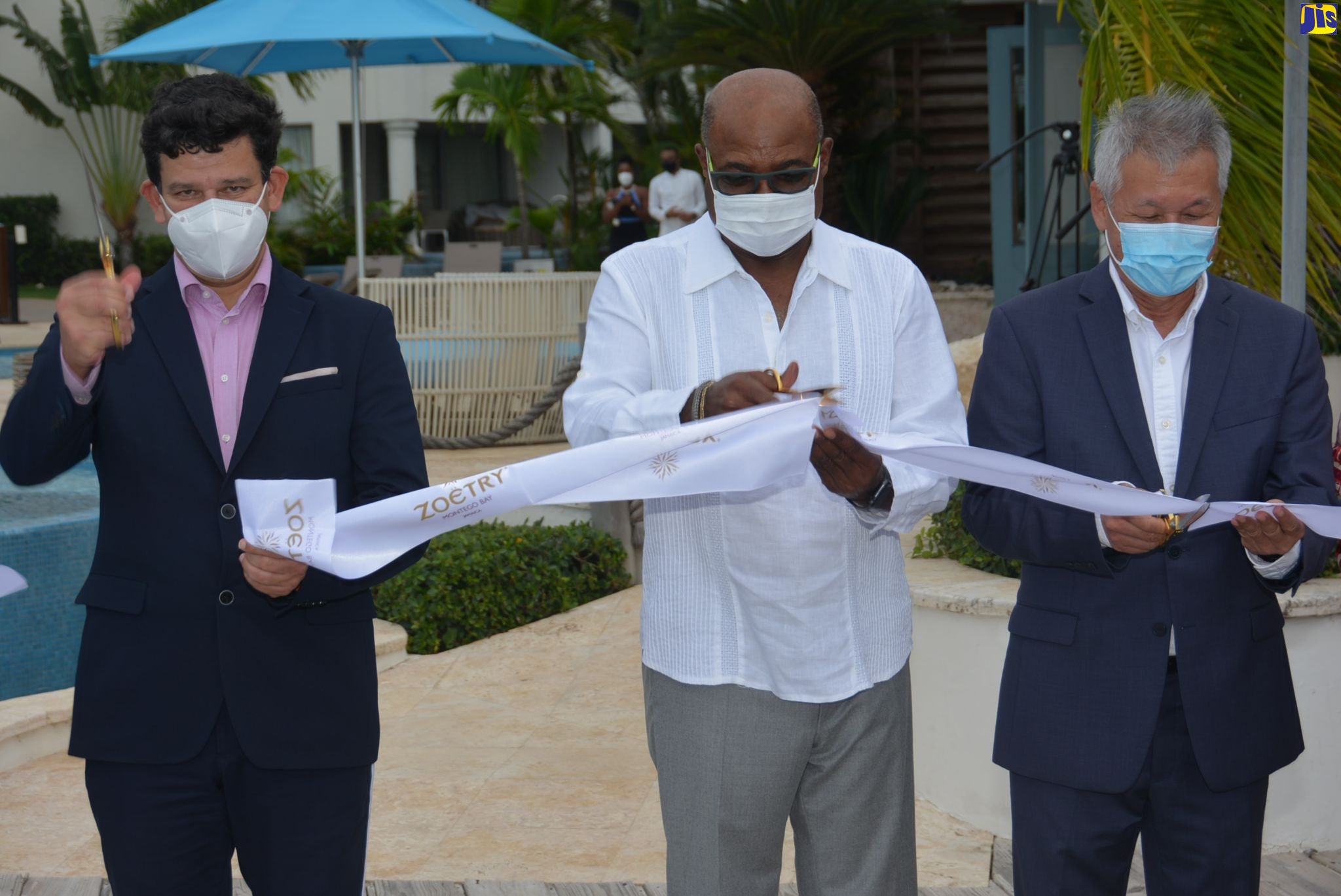 Minister of Tourism, Hon Edmund Bartlett (centre), is joined by Zoetry Montego Bay Directors, Kevin Robertson (left) and Steven Fong-Yee to cut the ribbon marking the reopening of Zoetry Montego Bay, in Ironshore, St. James, on Thursday (October 1).