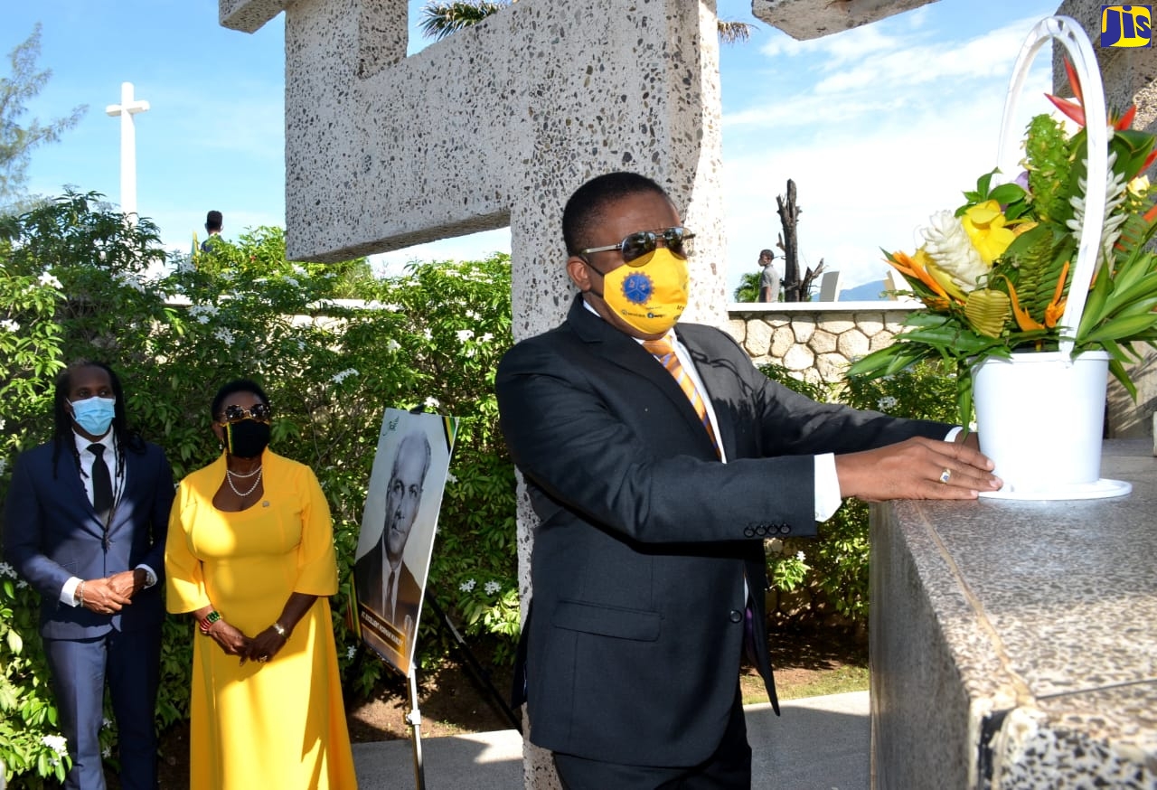 Member of Parliament for East Kingston and Port Royal, Phillip Paulwell (foreground), places flowers at the shrine of National Hero, the Rt. Excellent Norman Washington Manley, during a ceremony at National Heroes Park in Kingston, on Monday (October 19).  At centre is  Minister of Culture, Gender, Entertainment and Sport, Hon. Olivia Grange and at left is Minister of State in the Culture Ministry, Hon. Alando Terrelonge. The event formed part of activities commemorating National Heroes’ Day.  Mr. Paulwell represented Leader of the Opposition, Dr. Peter Phillips.