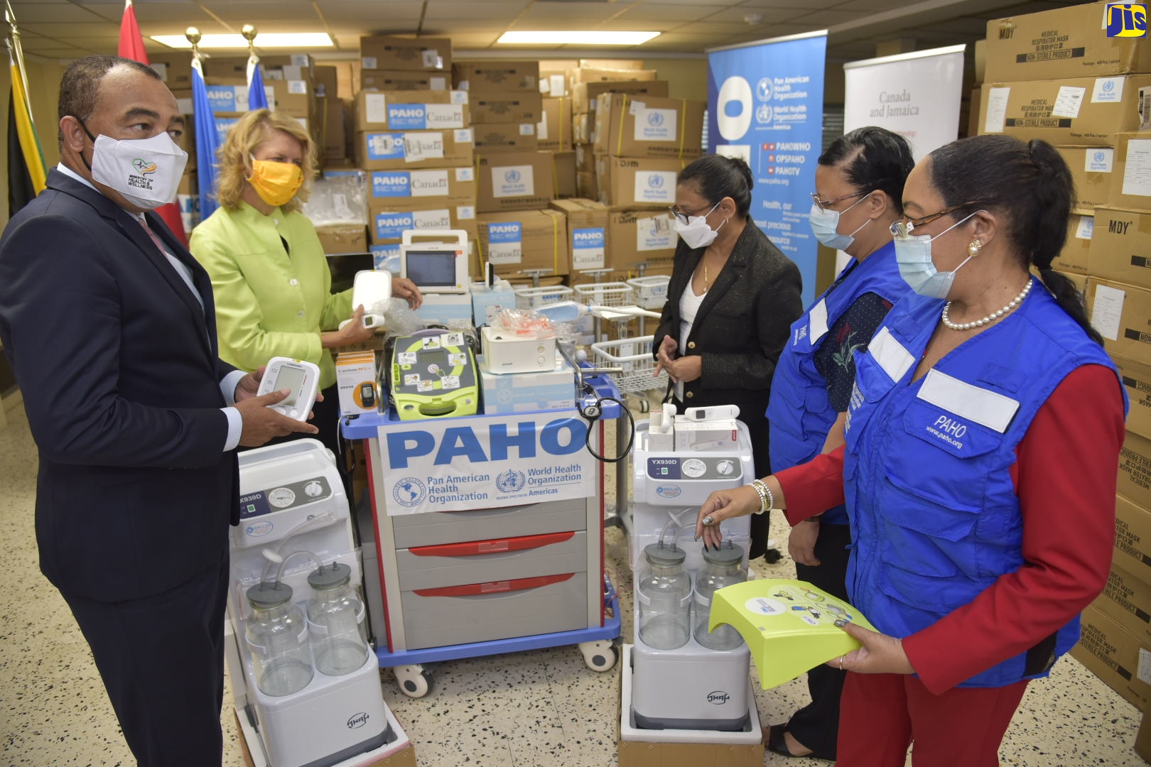 Minister of Health and Wellness, Dr. the Hon. Christopher Tufton (left), speaks to Technical Advisor, Health Emergencies, Pan American Health Organization (PAHO), Dr. Marion Bullock DuCasse (right), about the items handed over to the Ministry of Health and Wellness at the offices of PAHO/WHO, at the University of the West Indies, Mona, on Tuesday (October 6). PAHO handed over 15 intensive-care unit beds, 13 satellite phones, thermometers, scanners and KN 95 masks. Examining the items are Chief Medical Officer, Dr. Jacquiline Bisasor-McKenzie (second right); High Commissioner of Canada to Jamaica, Her Excellency Laurie Peters (second left); and PAHO/WHO Representative to Jamaica, Bermuda and the Cayman Islands, Dr. Bernadette Theodore-Gandi.