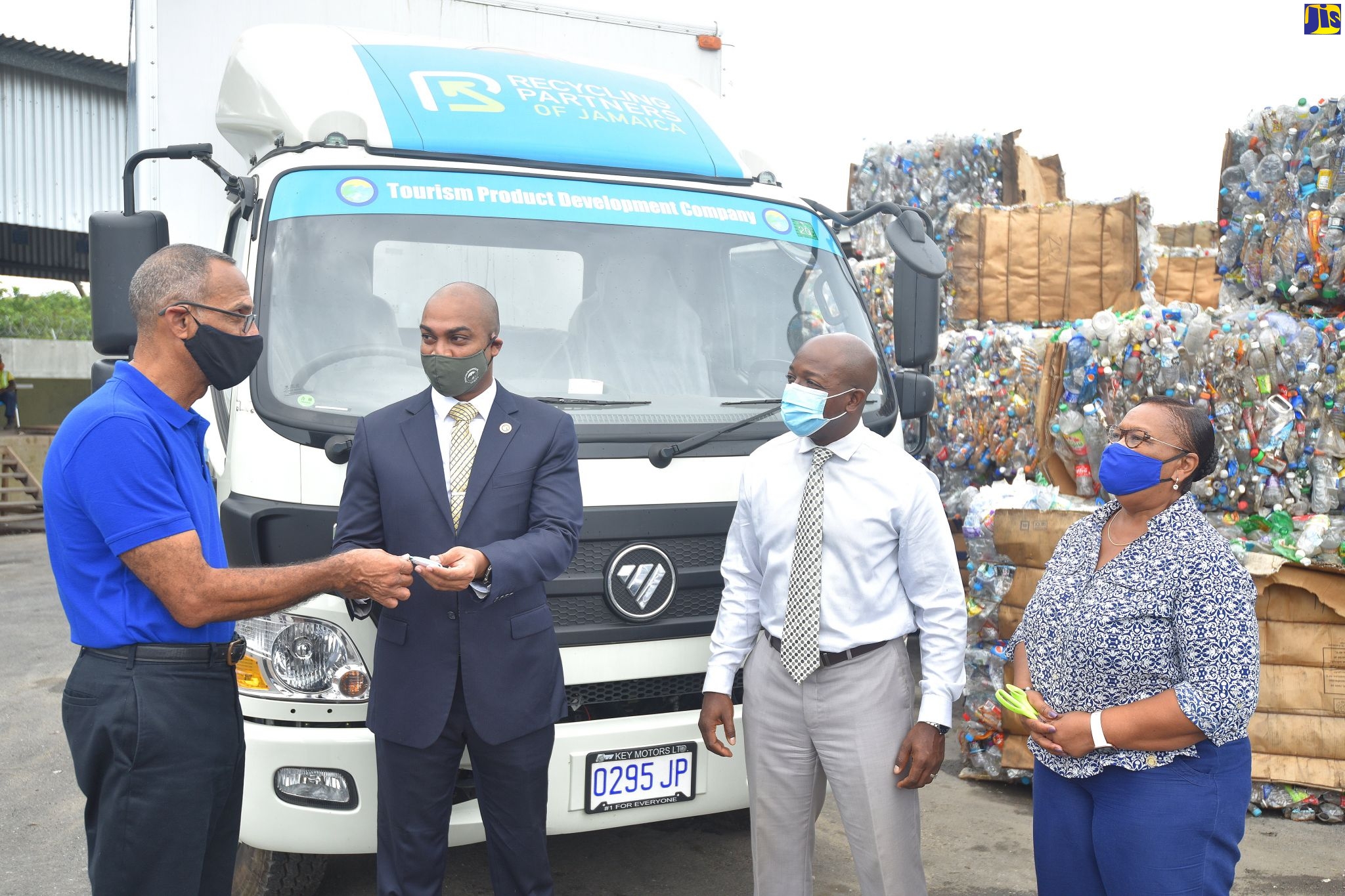 Minister of Housing, Urban Renewal, Environment and Climate Change, Hon. Pearnel Charles Jr. (third left), observes as Chairman, Recycling Partners of Jamaica Limited (RPJ), Damien King (left), accepts keys for a box truck from Acting Executive Director, Tourism Product Development Company (TPDCo.), Stephen Edwards, during the handover ceremony,  on Wednesday (October 21), at the recycling company’s Lake’s Pen address in St. Catherine.  At right is Chief Financial Officer,  RPJ, Wincella Cummings.