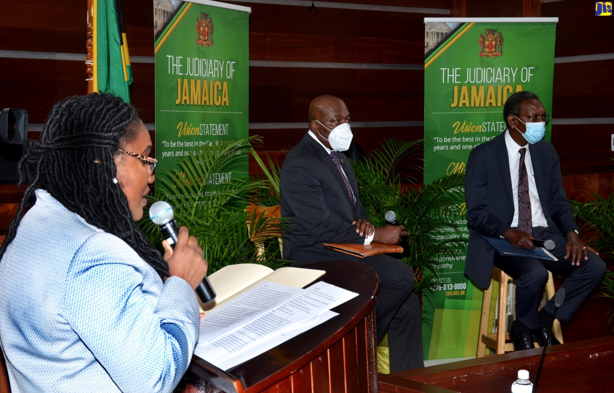 Acting Director of the Court Administration Division (CAD), Tricia Cameron Anglin (left), addresses persons at the Conversation with the Judiciary, held at the Supreme Court on October 29. Seated (from second left) are Chief Justice, Brian Sykes; and President of the Court of Appeal, Hon. Justice Dennis Morrison.