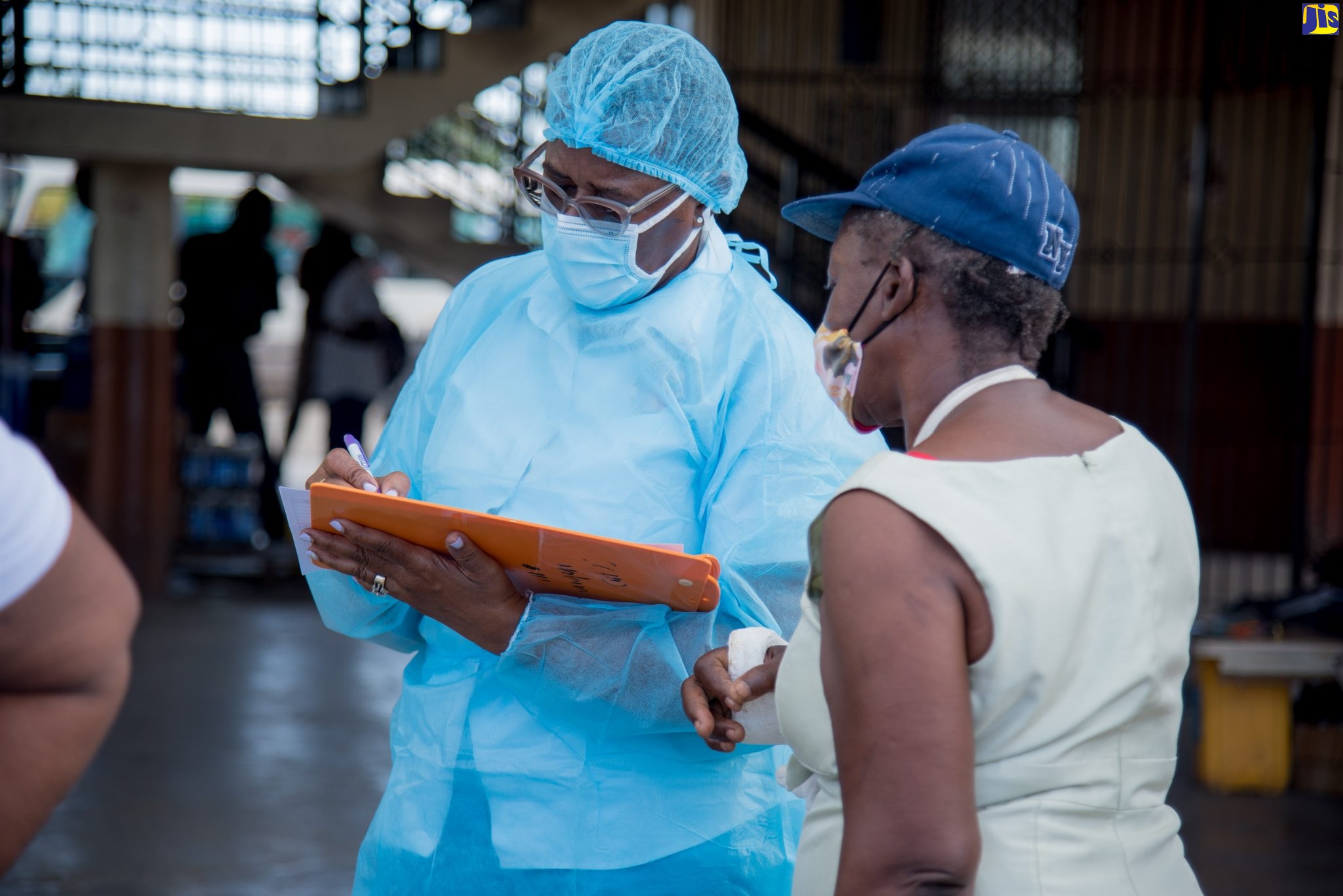 Community Health Aide (CHA), St. Catherine Health Department, Margaret Simms (left), takes information from a member of the public, during a free coronavirus (COVID-19) testing exercise at the Spanish Town Bus Terminus on Friday (November 27).