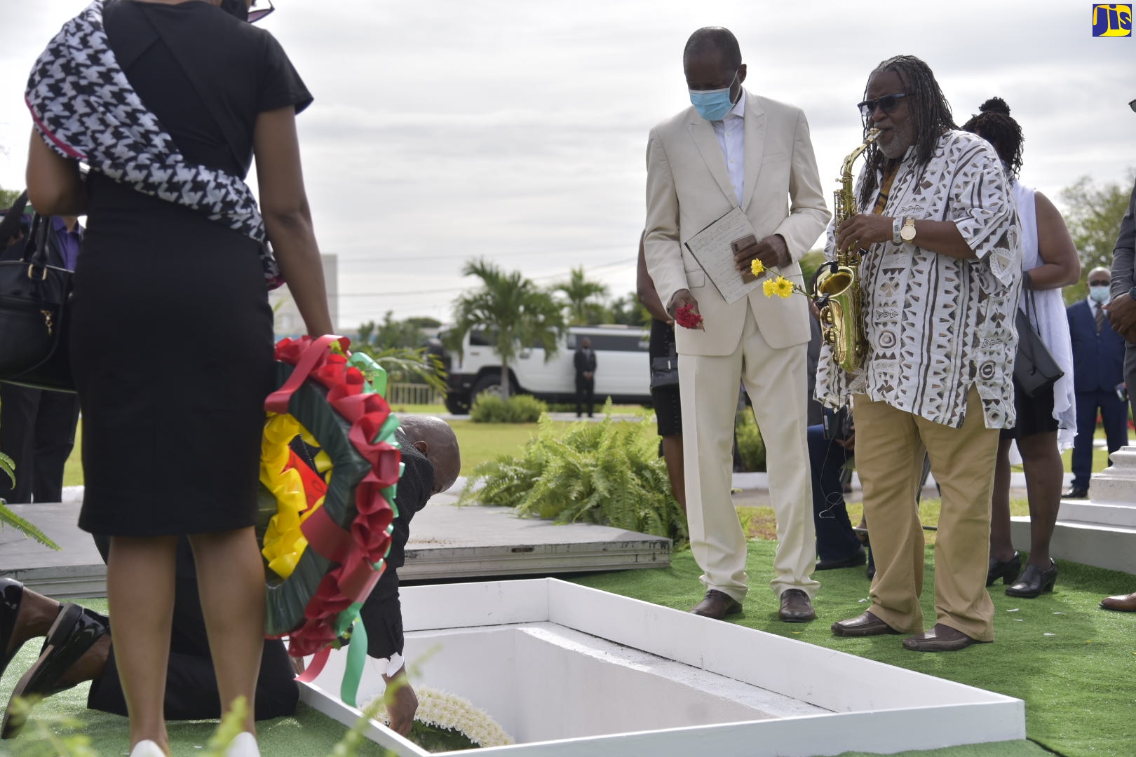 Performers, saxophonist - Dean Fraser (right), and singer - Demario McDowell (second right), prepare to lay a floral tribute at the grave of late Reggae singer, Frederick ‘Toots’ Hibbert, during his interment service at the National Heroes Park in Kingston on Sunday (November 15).

