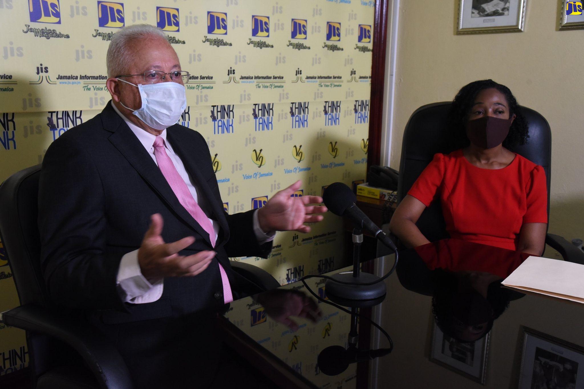 Justice Minister, Hon. Delroy Chuck, speaking in a recent JIS Think Tank. Looking on is Chief Parliamentary Counsel, Judith Grant.