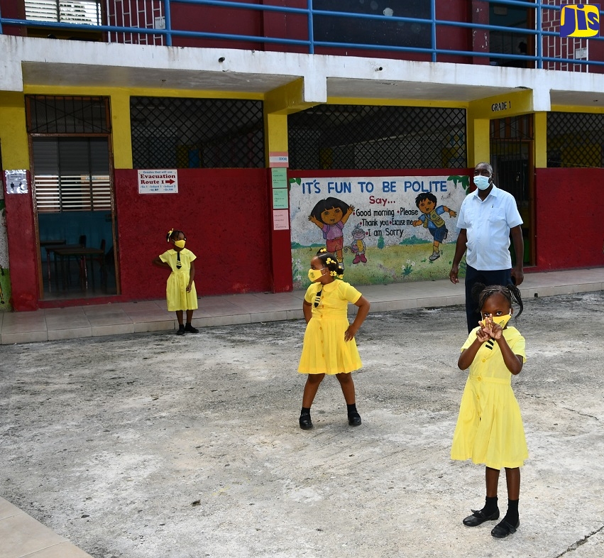 Principal at the Somerton All-Age and Infant School in St. James, Glendon Brydson, engages students of the infant department on the first day of face-to-face classes at the Institution, on Tuesday (November 10). The school is one of 17 primary and secondary institutions across the island participating in the Government’s two-week pilot programme.