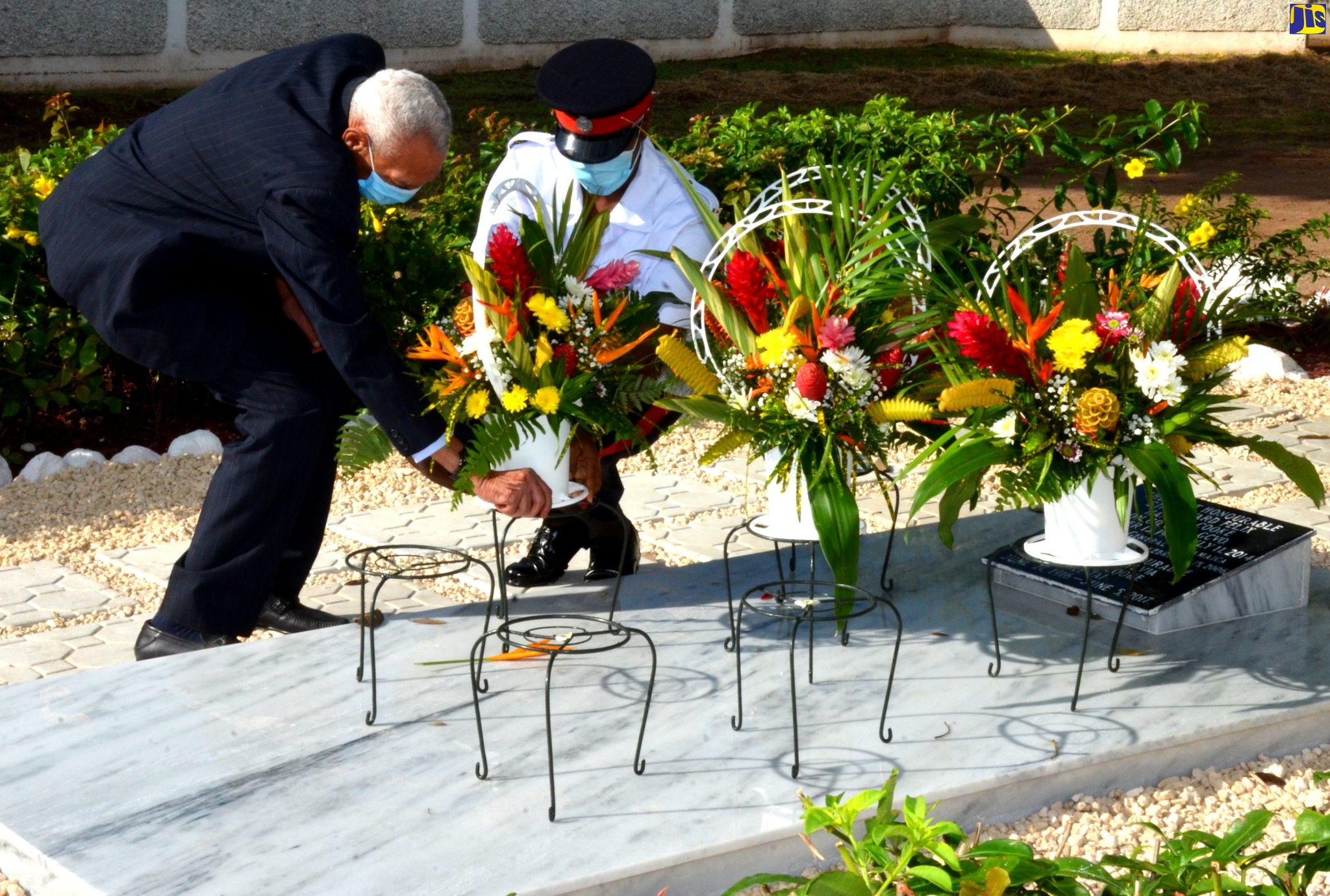 Hon. Justice Howard Fitz-Arthur Cooke (left) lays flowers for his late father, former Governor-General, His Excellency the Most Hon. Sir Howard Cooke, to mark the 105th anniversary of his birth, during a ceremony at National Heroes Park on November 13.