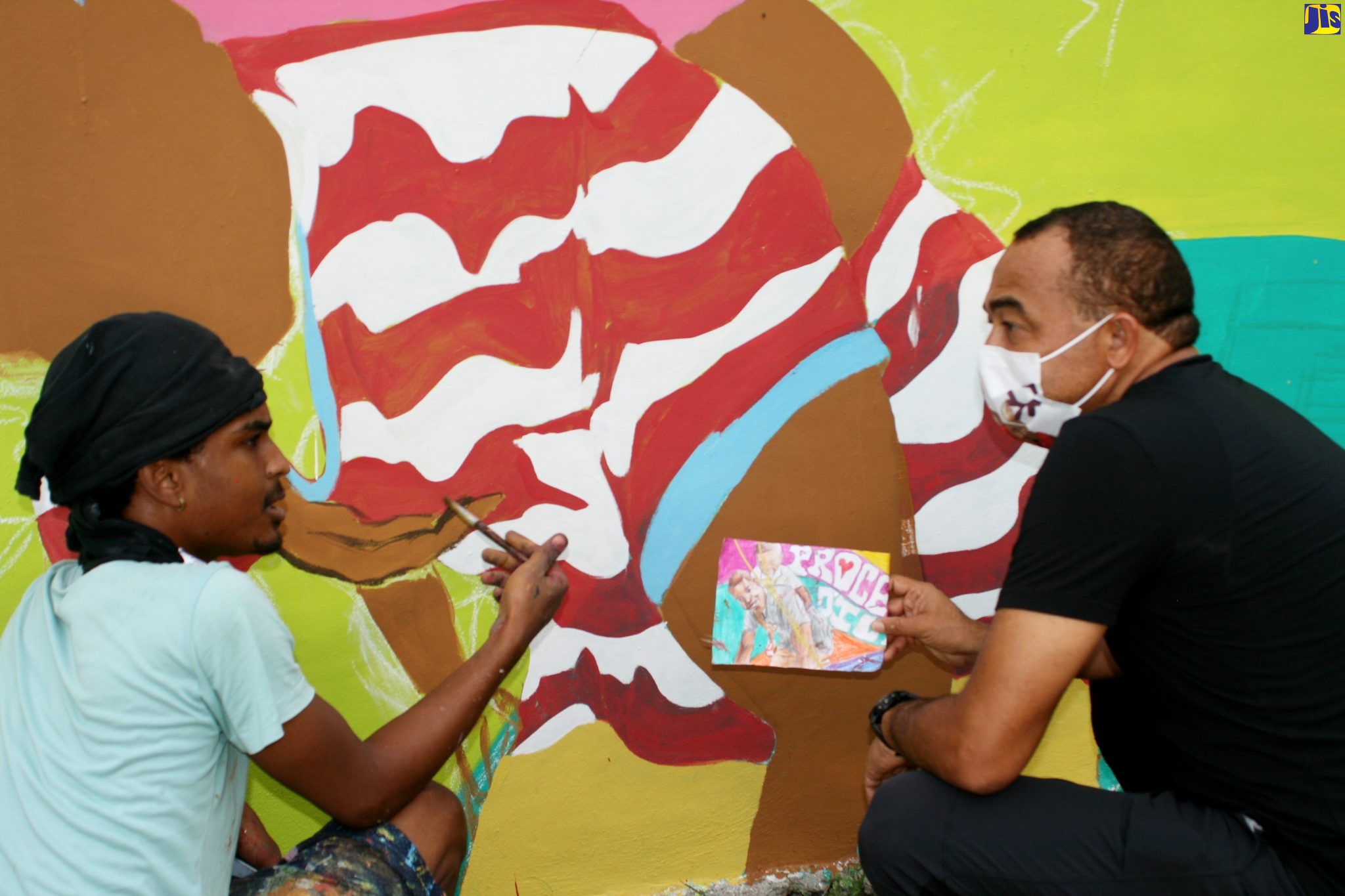 Member of Parliament for West Central St. Catherine, Dr. the Hon. Christopher Tufton (right), in discussion with student at the Edna Manley College of the Visual and Performing Arts, Brad Pinnock, at the entrance of the Frazer’s Content community, in the parish, where a major beautification project is under way, at a cost of $6 million provided by the Tourism Product Development Company (TPDCo). The Minister visited the community on December20.