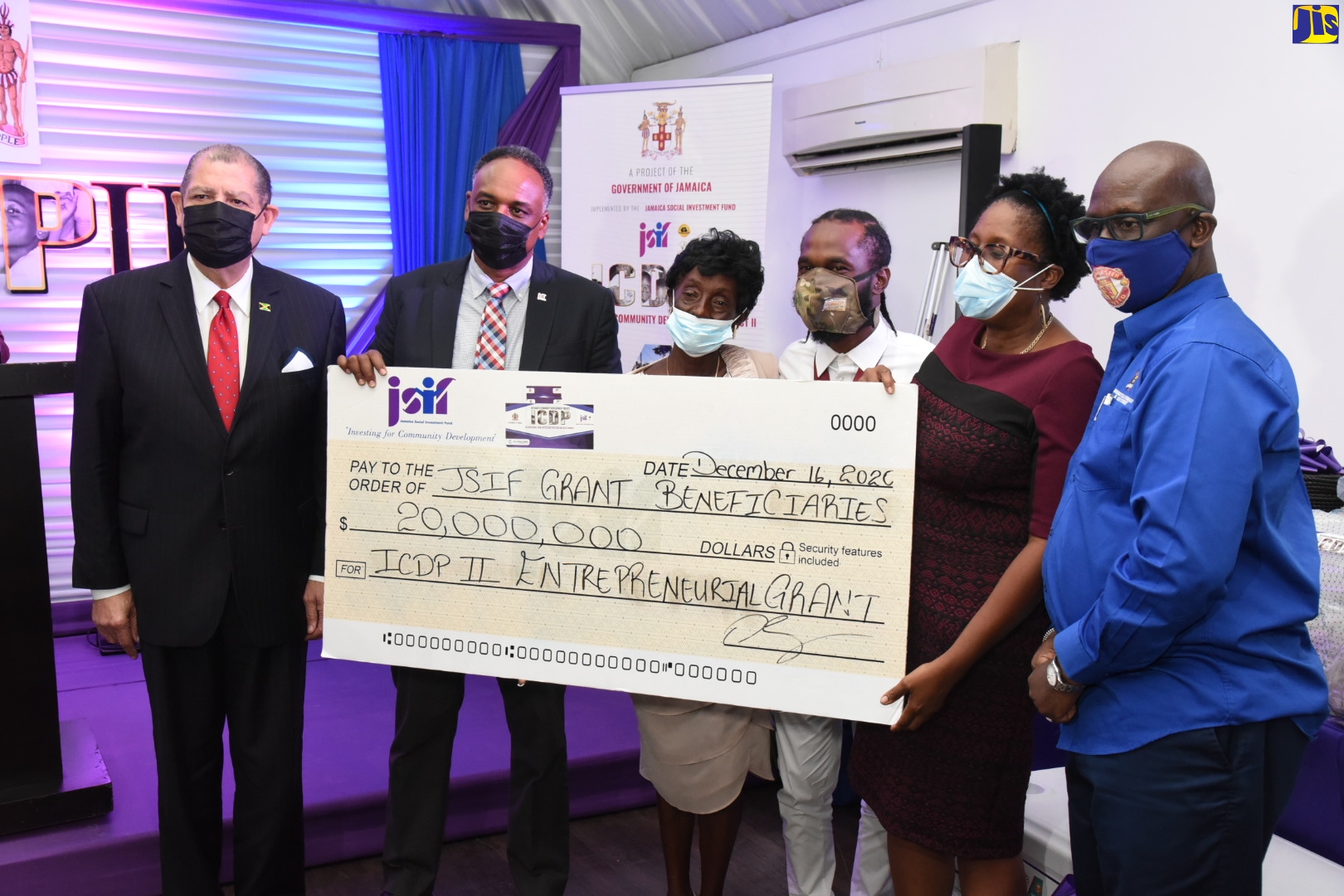 Minister of Industry, Investment and Commerce, Hon. Audley Shaw (left), shares in the symbolic handover of a cheque valued at $20 million by the Jamaica Social Investment Fund (JSIF) to benefit community entrepreneurs under the Enterprise Development Project. Others from (second left) are Managing Director, JSIF, Omar Sweeney; beneficiaries Lorna Green and Shawn Castell; Opposition Spokesperson on Education and Training, Dr. Angela Brown Burke; and Minister of Local Government and Rural Development, Hon. Desmond McKenzie. Occasion was the official launch of the project at the Spanish Court Hotel in New Kingston on December 16.