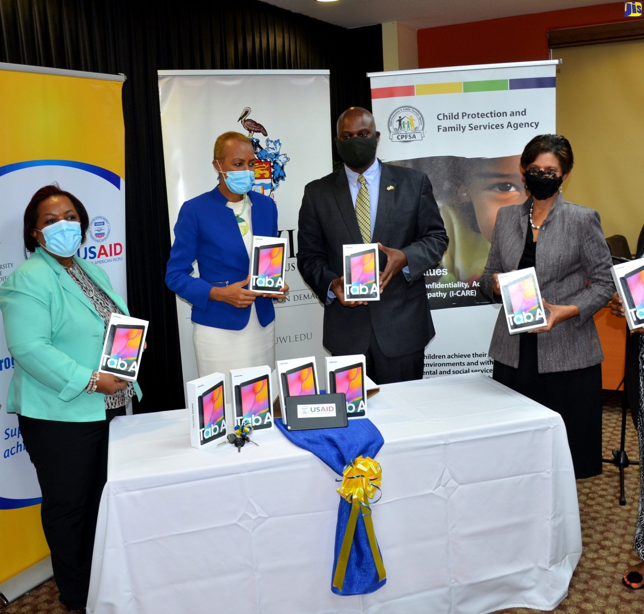 Minister of Education, Youth and Information, Hon. Fayval Williams (second left) and Country Representative, United States Agency for International Development (USAID), Jason Fraser (third left), display tablets during the handover of 1,500 of the devices by the USAID to the Child Protection and Family Services Agency (CPFSA), under the Ministry