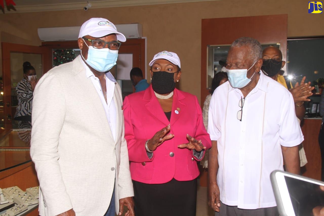 Minister of Culture, Gender, Entertainment and Sport, Hon. Olivia Grange (centre), has the full attention of Minister of Tourism, Hon. Edmund Bartlett (left); and Chairman of the Tourism Enhancement Fund (TEF), Godfrey Dyer, at the official opening of the newly renovated and rebranded Main Street Jamaica facility in Rose Hall, St. James, on December 16.