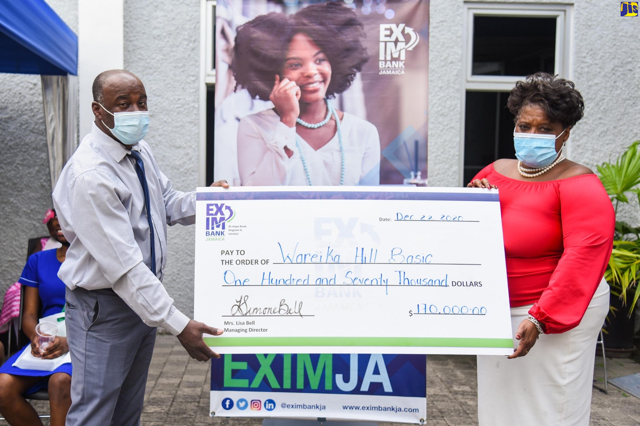 Managing Director of the National Export-Import Bank of Jamaica (EXIM Bank), Lisa Bell (right), presents a cheque for $170,000 to the Wareika Hill Basic School to assist with the institution’s restoration project. The symbolic cheque was collected by Member of EXIM Bank’s Welfare Committee, Junior Gordon, on Tuesday (December 22) during the Bank’s ‘Carolling in the Courtyard’ event at its head office on Hope Road in Kingston.