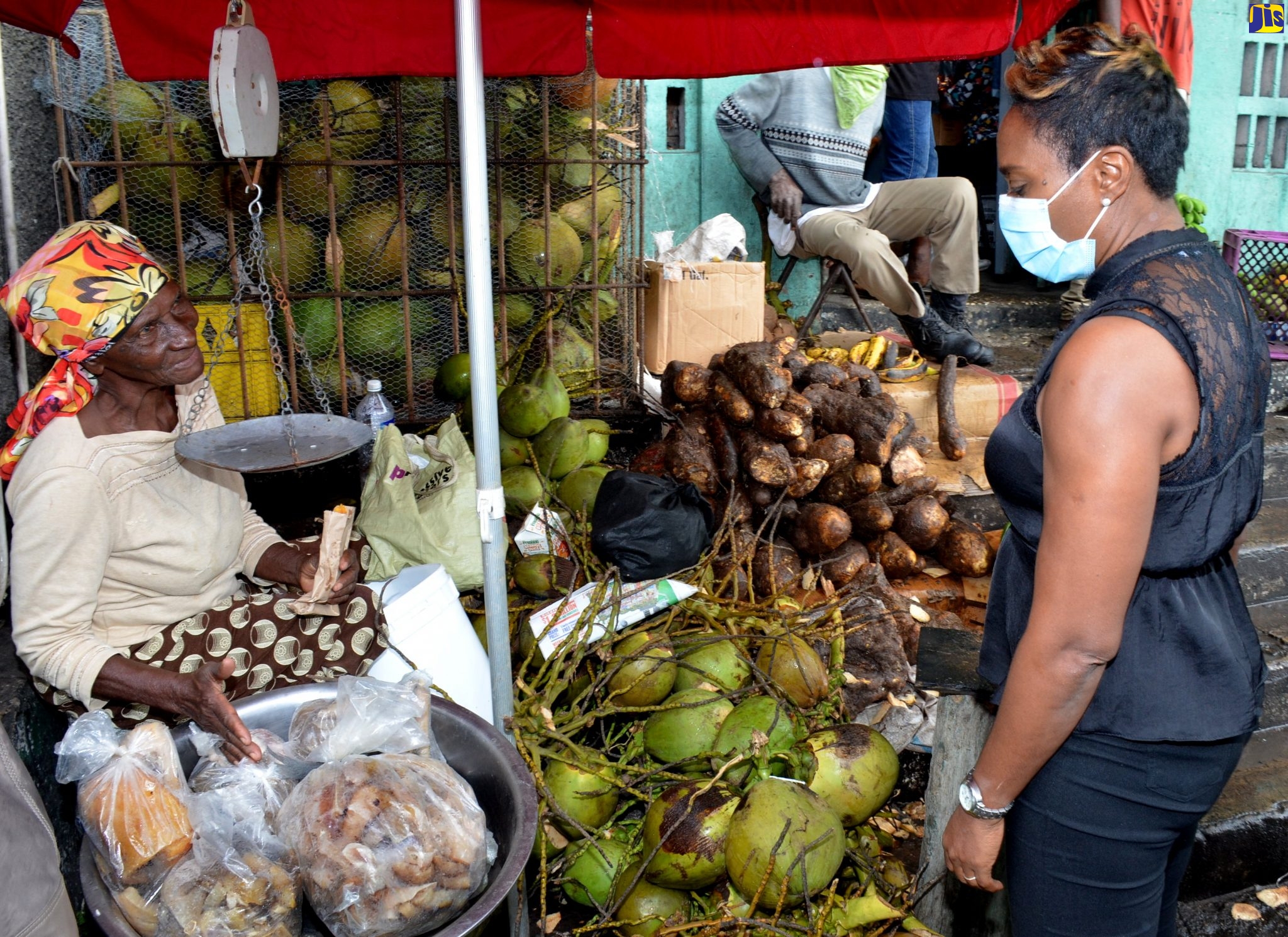 State Minister in the Ministry of Health & Wellness (right), Hon. Juliet Cuthbert Flynn, in conversation with vendor, Stony Hill market, Hermine Walker, during a ‘Market Pop Up’ on December 19. The State Minister also presented a mask to her.
