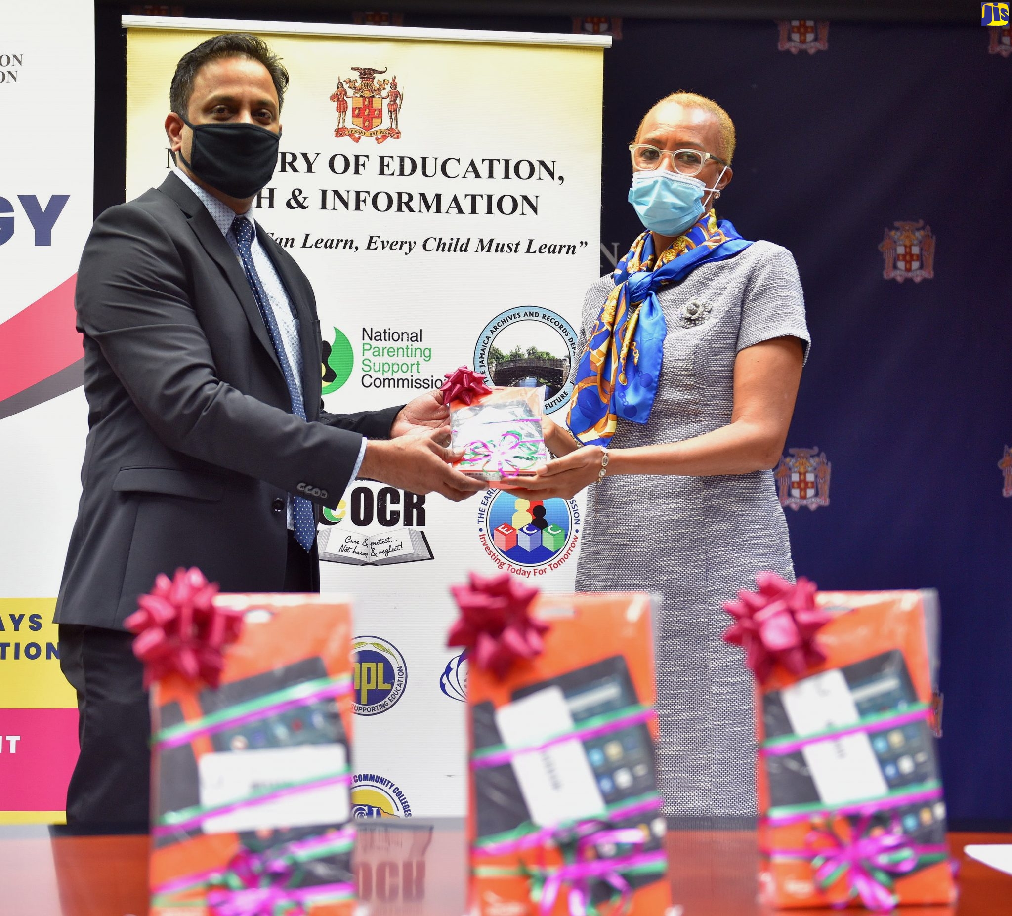 Minister of Education, Youth and Information, Hon. Fayval Williams (right), accepts a tablet from General Manager, Berger Paints Jamaica, Shashi Mahase, during his visit to the Ministry