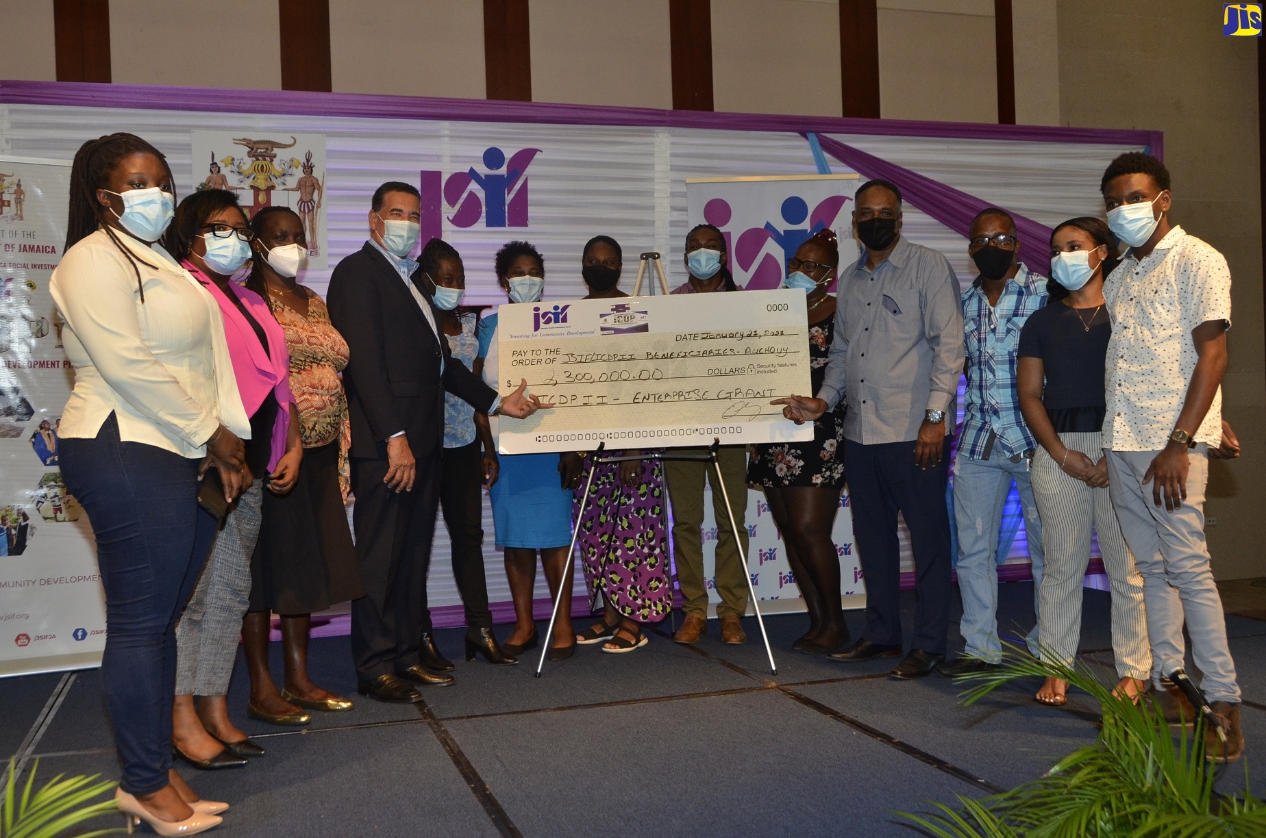 Minister of State in the Ministry of Local Government and Rural Development, Hon. Homer Davis (left), and Managing Director of the Jamaica Social Investment Fund (JSIF), Omar Sweeney (right), display a cheque for $2.3 million to procure equipment for 11 microenterprises in Anchovy, in St. James, at a handover ceremony, held at the Montego Bay Convention Centre, in Rose Hall, on Thursday, January 21.
