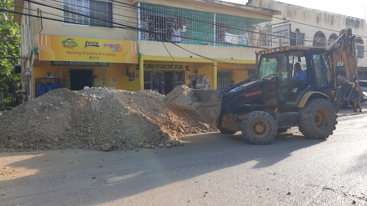 A National Works Agency (NWA) worker clears a section of the Lethe roadway in St. James after the area was heavily flooded last Saturday.

