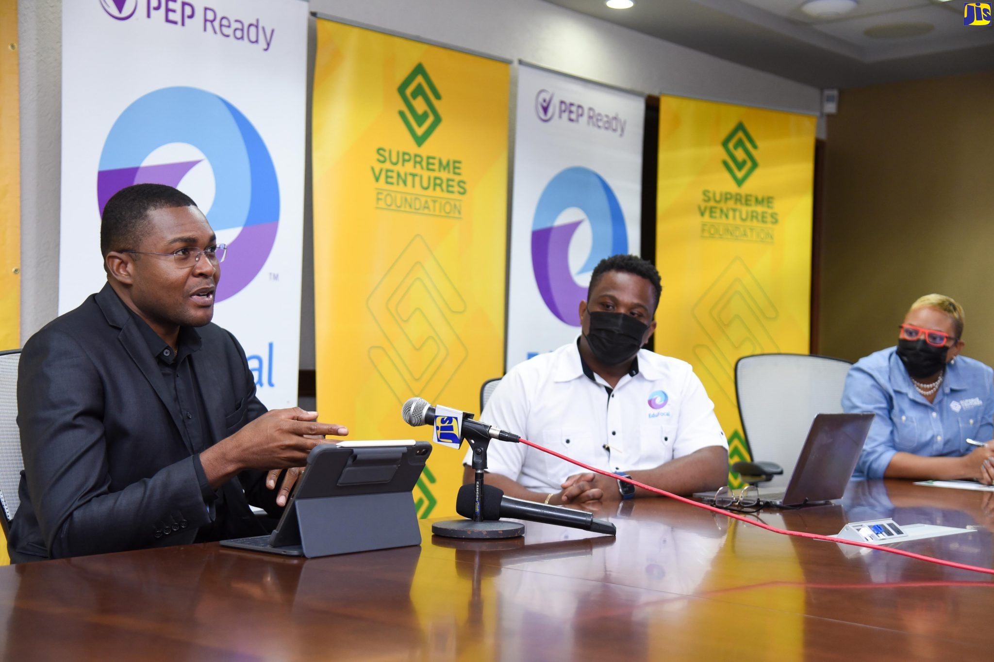 Minister of State in the Ministry of Education, Youth and Information, Hon. Robert Morgan (left), addresses the launch of a partnership between the Supreme Ventures Foundation and EduFocal, to provide 5000 students with free access to EduFocal’s learning platform. The function took place on Friday (Jan. 22), at Supreme Ventures Limited’s (SVL) offices in Kingston. Listening are Chief Executive Officer of EduFocal, Gordon Swaby (centre) and Vice President for Marketing and Communications at SLV, Gail Abrahams.