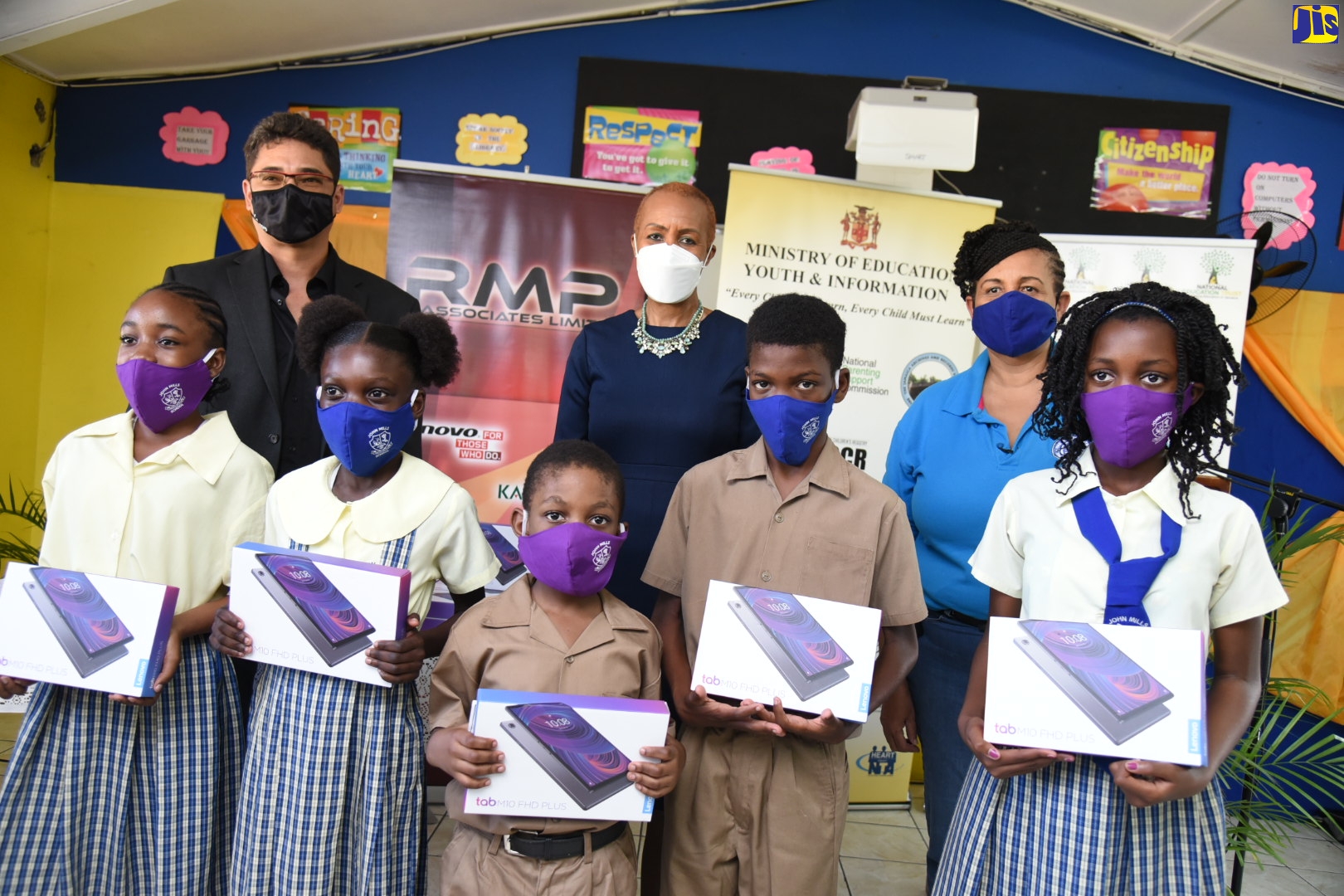 Minister of Education, Youth and Information, Hon. Fayval Williams (back row, centre) is joined by Chief Executive Officer of donor company, RMP & Associates Limited, Reece Kong (back row, left); and Interim Chief Executive Officer, Private Sector Organisation of Jamaica (PSOJ), Greta Bogues, at the handover of tablets to students of John Mills Primary and Infant school, at the institution in Kingston on Friday (January 22). Proudly displaying their tablets (from left, front row are): Shanalee Garwood, Sanique Watt, Douglas Augustine, Theyo Turner and Sashana Dailey.