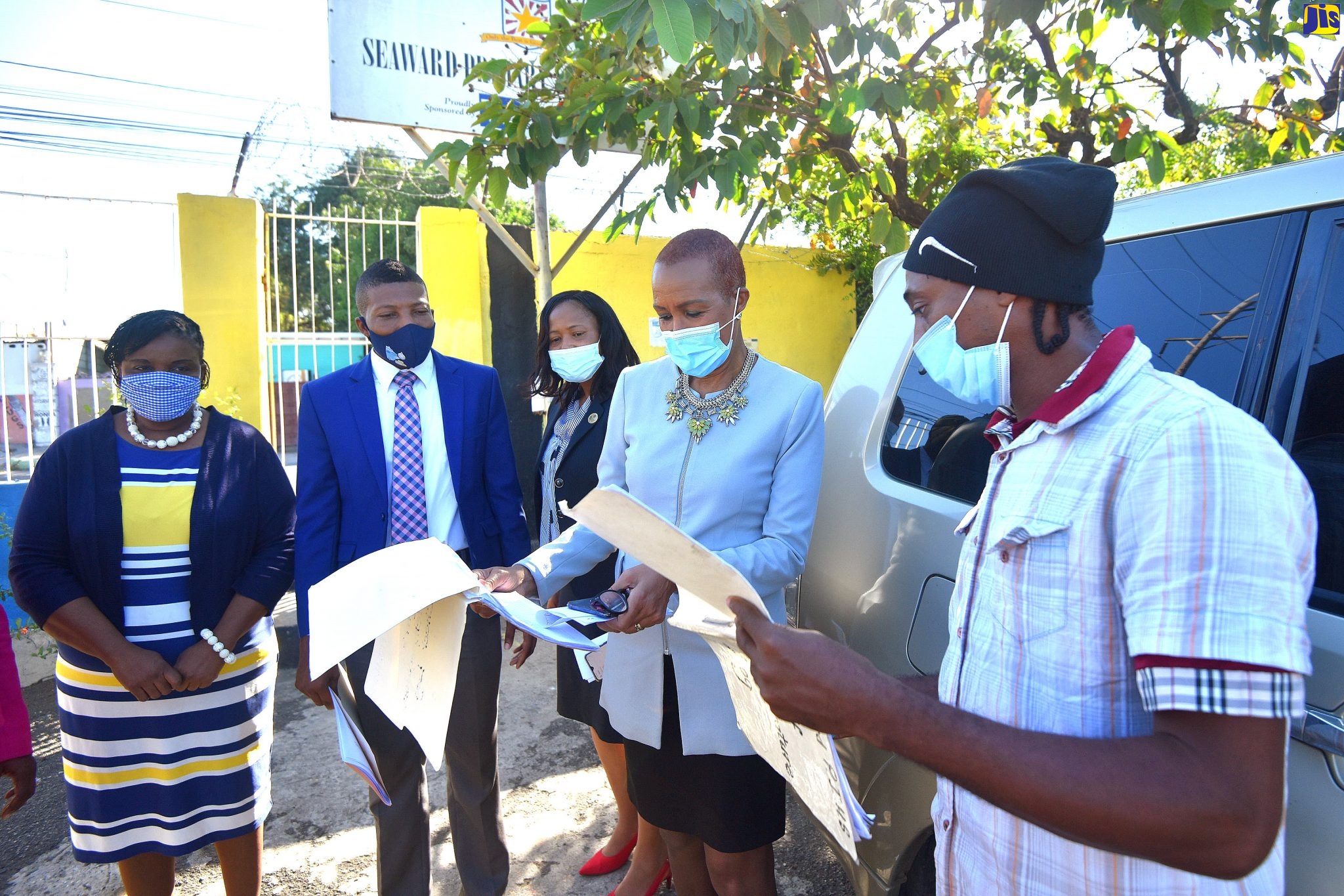 Minister of Education, Youth and Information, Hon. Fayval Williams (second right), looks at the temperature log for students of Seaward Primary & Junior High School in Kingston during a visit to the institution on Tuesday (January 5). Looking on (from left) are Principal, Arlene Thomas; Education Officer, Ricardo Kennedy; Acting Regional Director, Region 1, Dasmine Kennedy; and Security Guard at the school, Garfield Gordon (right).