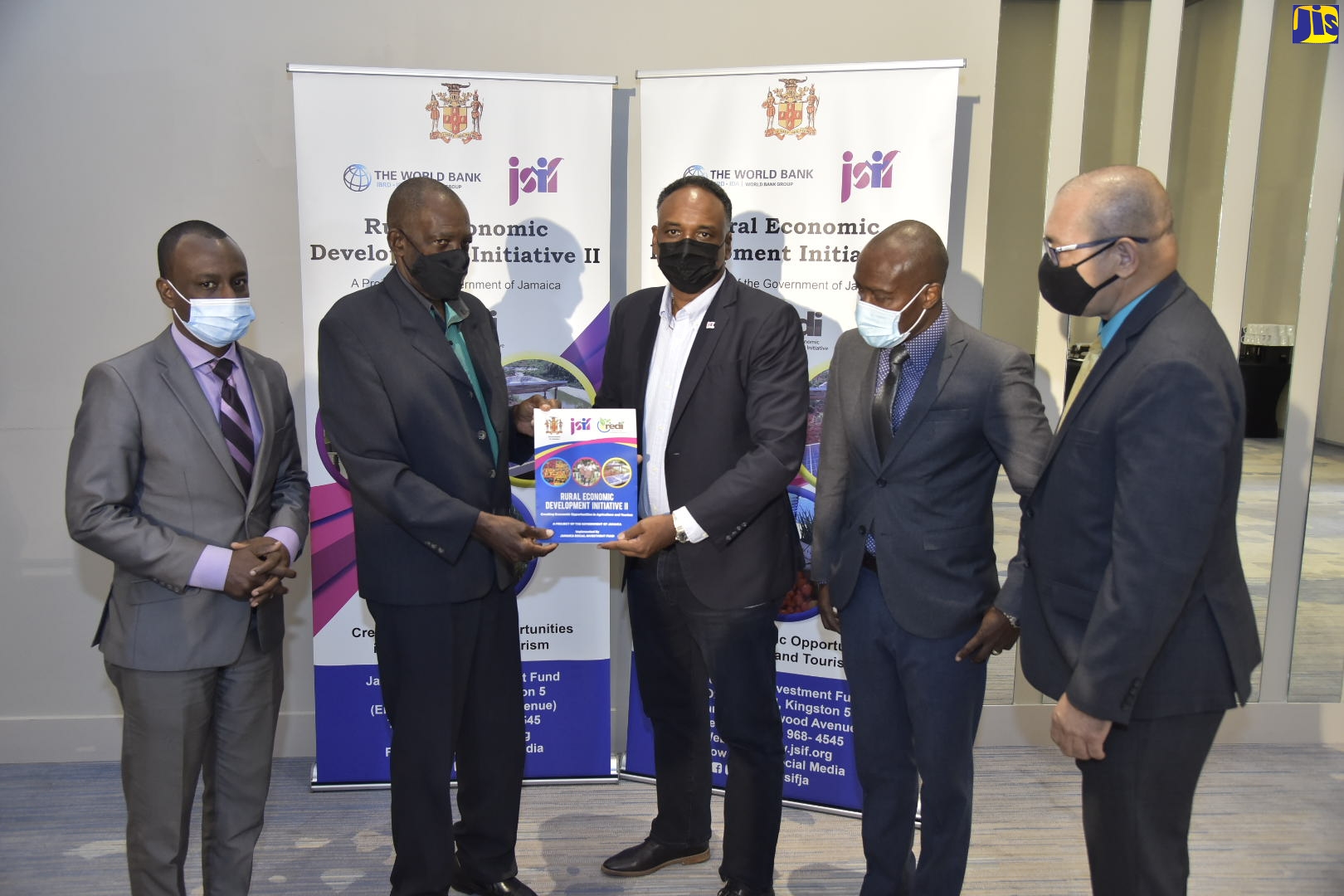 Minister of State in the Ministry of Transport and Mining, Hon. J.C. Hutchinson (second left) and Managing Director, Jamaica Social Investment Fund (JSIF), Omar Sweeney (centre), display the document formalising the partnership between JSIF and the Jamaica Bauxite Institute (JBI) for implementation of the second phase of the Rural Economic Development Initiative (REDI II) water harvesting and greenhouse cluster project, during a signing ceremony at the AC Kingston Marriot Hotel, on February  26. Sharing the moment (from left) are: General Manager, JBI, Stevie Barnett; Chief Technical Director in the Ministry of Agriculture and Fisheries, Courtney Cole; and General Manager, Finance, JSIF, Orville Hill.