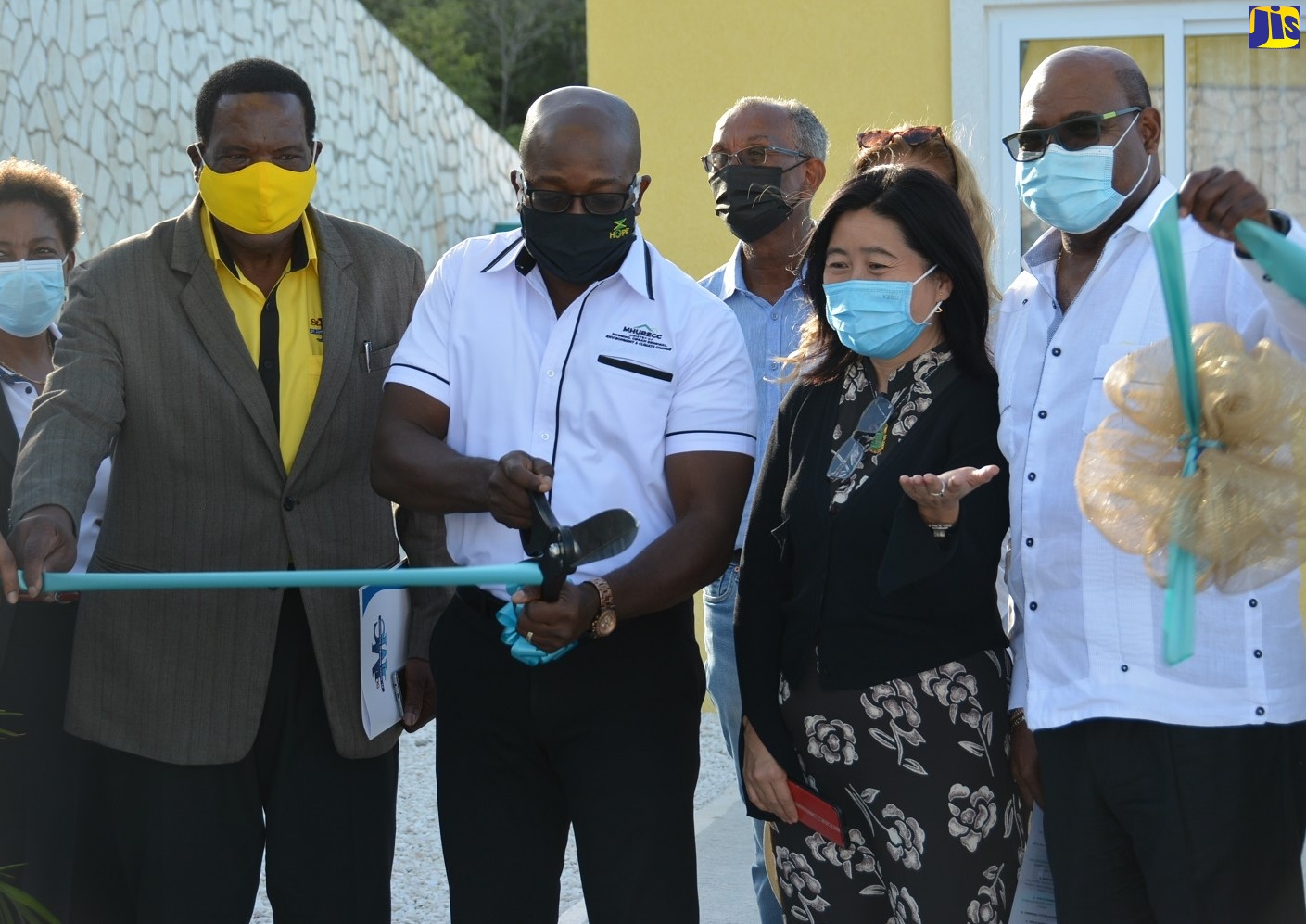Minister of Housing, Urban Renewal, Environment and Climate Change, Hon. Pearnel Charles Jr (centre), cuts the ribbon to launch the first of three model housing units under phase one of the Edmund Ridge Estate in Rose Hall, St. James, on Thursday (February 25).  He is joined by  (from left) Mayor of Montego Bay, Councillor Leeroy Williams;  Director of Henan Fifth Construction Group Company Limited, Dong Wong; and Minister of Tourism, Hon. Edmund Bartlett, after whom the development is named.