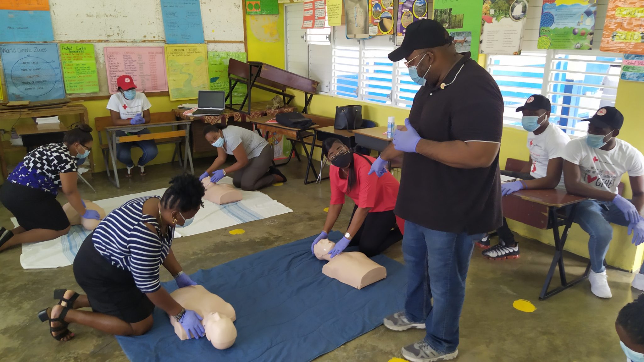 First Aid Instructor of the St. Elizabeth arm of the Jamaica Red Cross, Maceo Sibbles (standing), instructing staff of the St. Elizabeth Municipal Corporation and St. Elizabeth Infirmary on how to apply Cardiopulmonary resuscitation (CPR) with the help of CPR  manikins, during Thursday