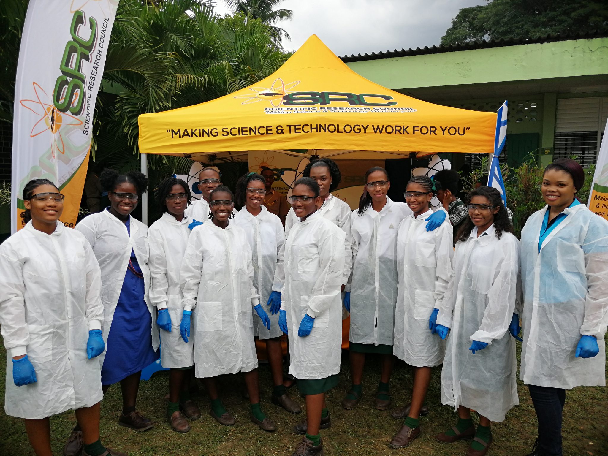 Coordinator of the SRC's Science and Technology Education Unit, Kavelle Hylton (right), with STEM students during a science fair held in 2019. 

